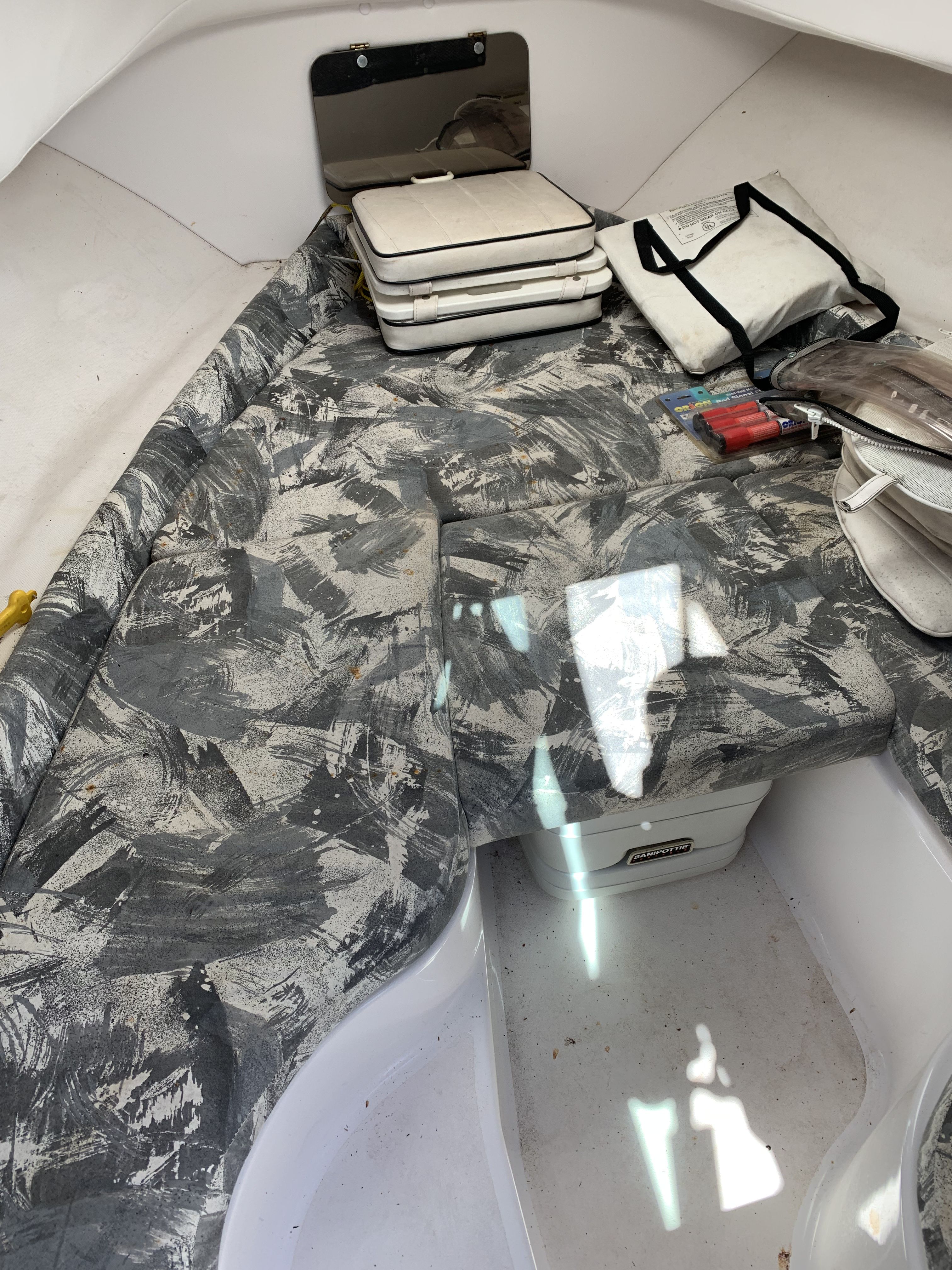 Interior of a 1999 Pro-Line 221 boat with patterned cushions and equipment.