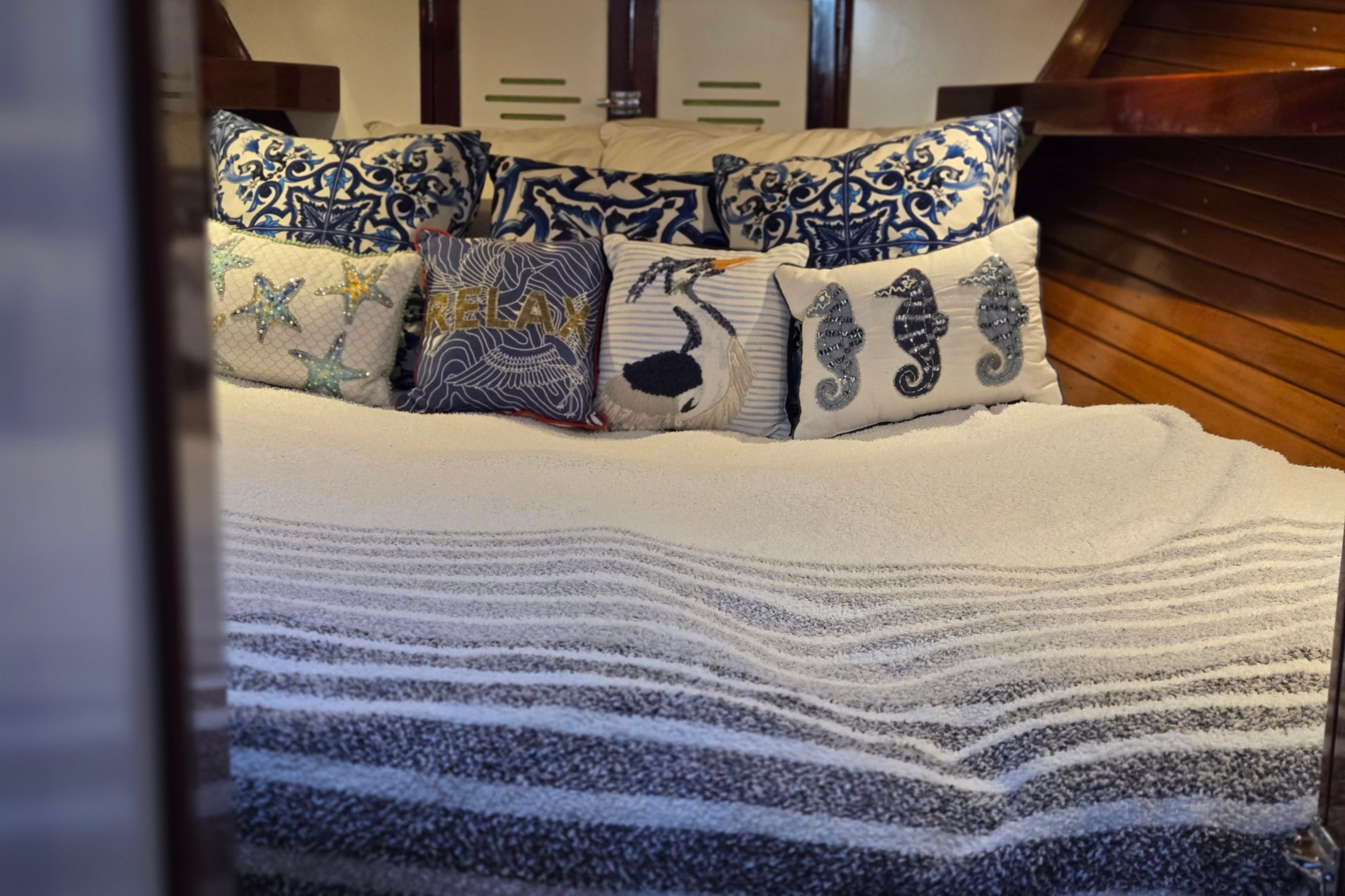 Cozy cabin interior of 1970 Hinckley Bermuda 40 with nautical-themed pillows.