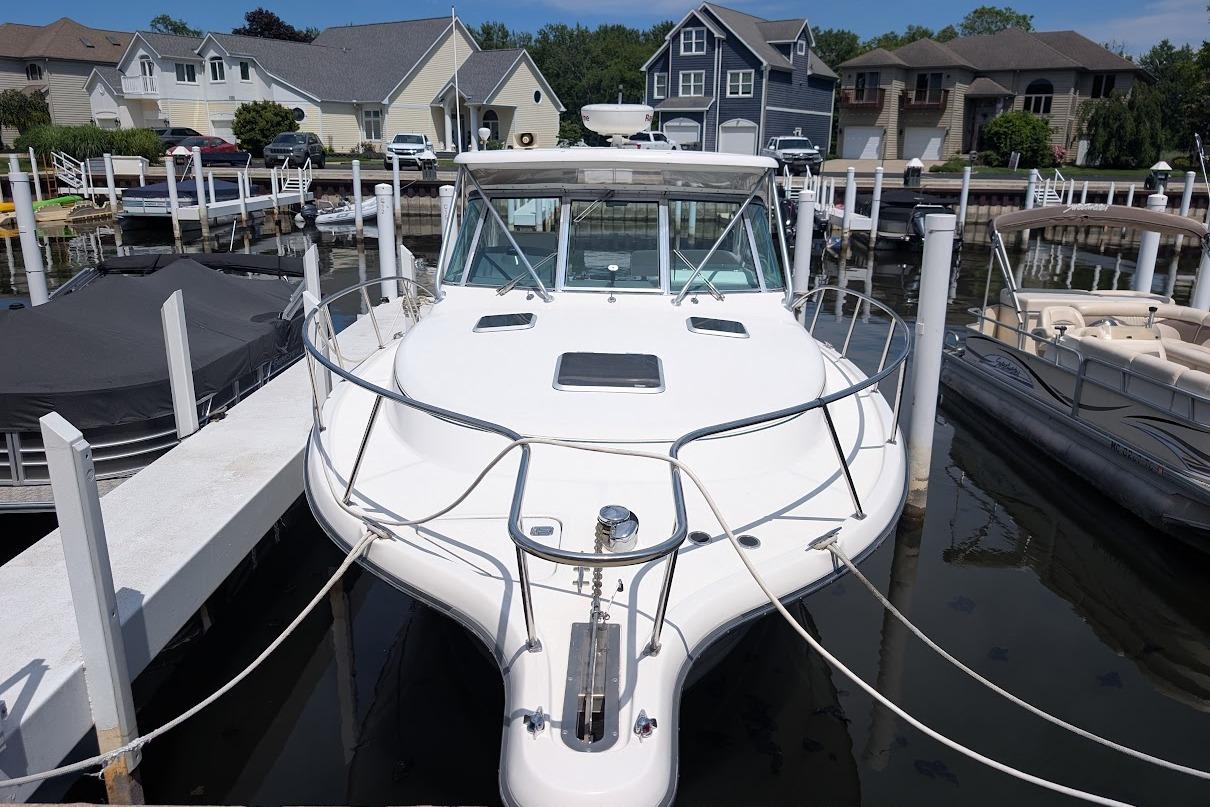 2000 Pursuit 3400 Express boat docked at marina, surrounded by residential homes.
