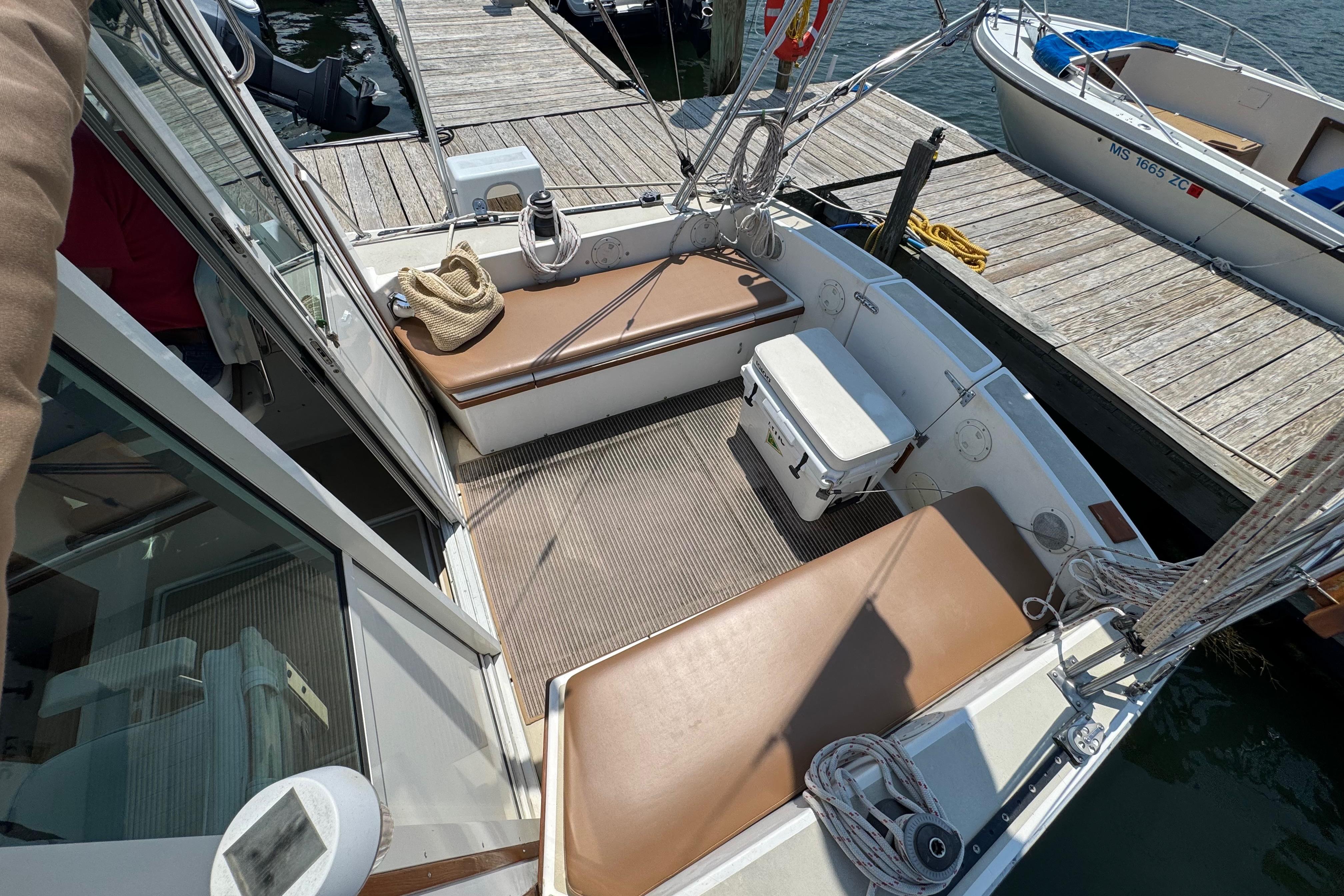 1989 Cape Dory 30 Motorsailer cockpit with seating, cooler, and dock view.