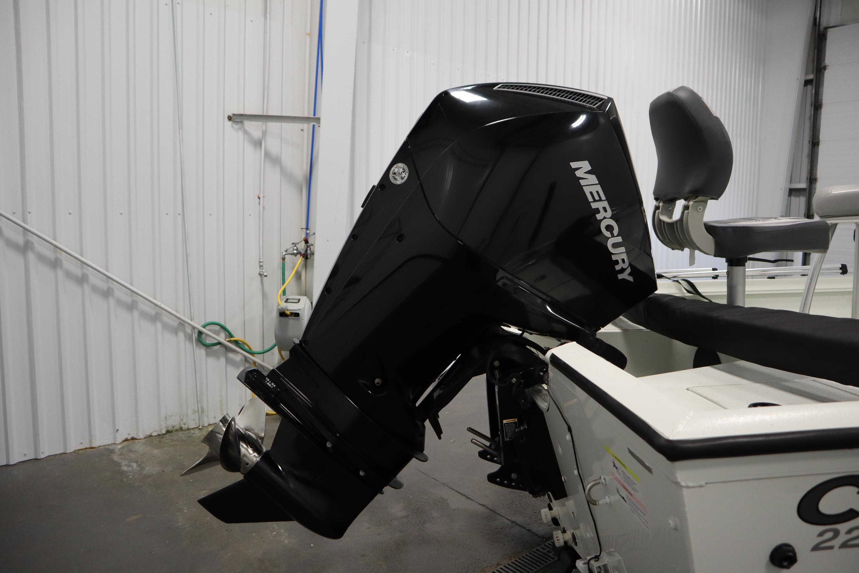 2022 Crestliner 2200 CC boat with Mercury outboard motor in a garage setting.