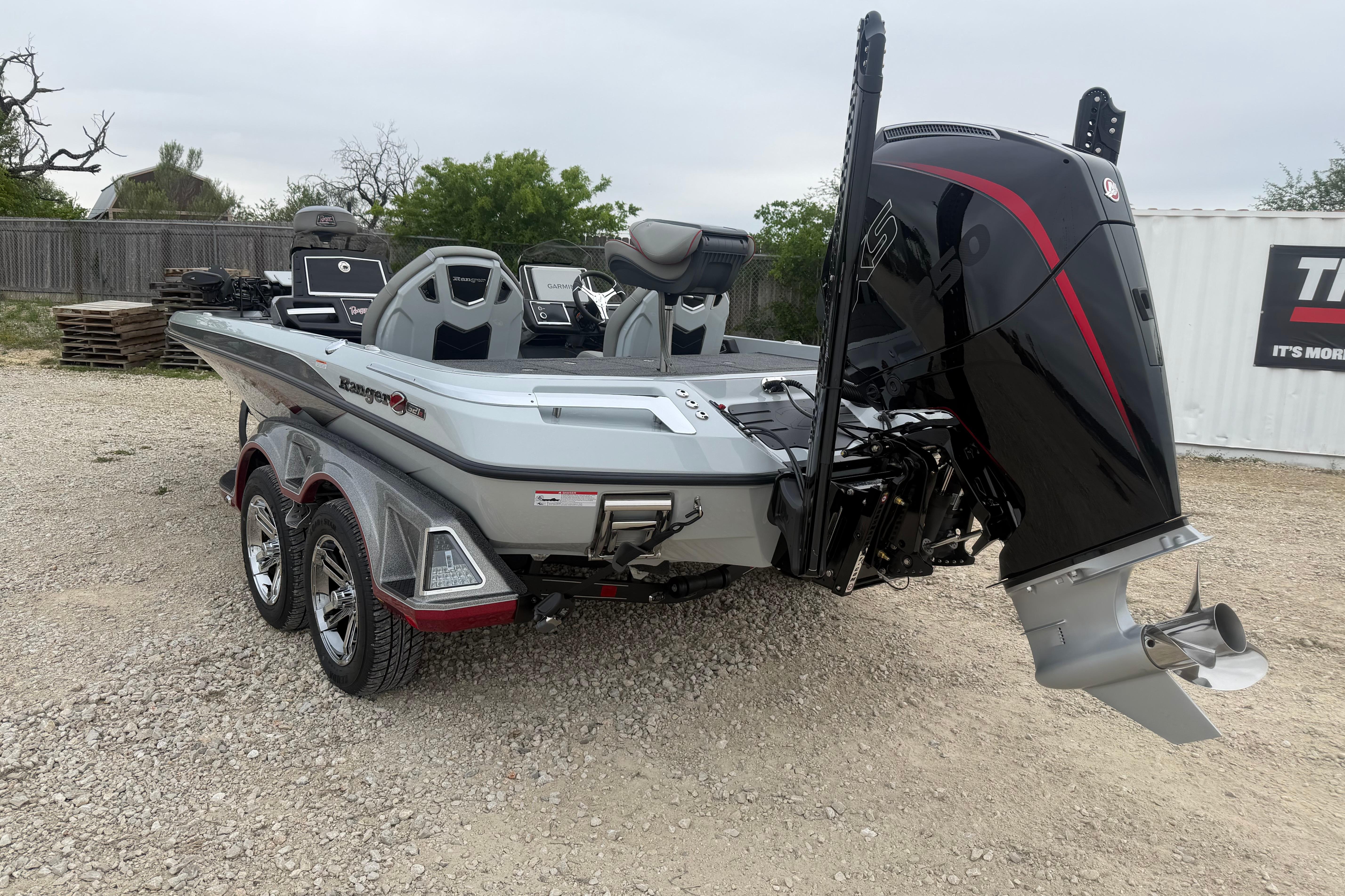 2026 Ranger Z521R Cup-Equipped boat with powerful outboard motor, parked on gravel.