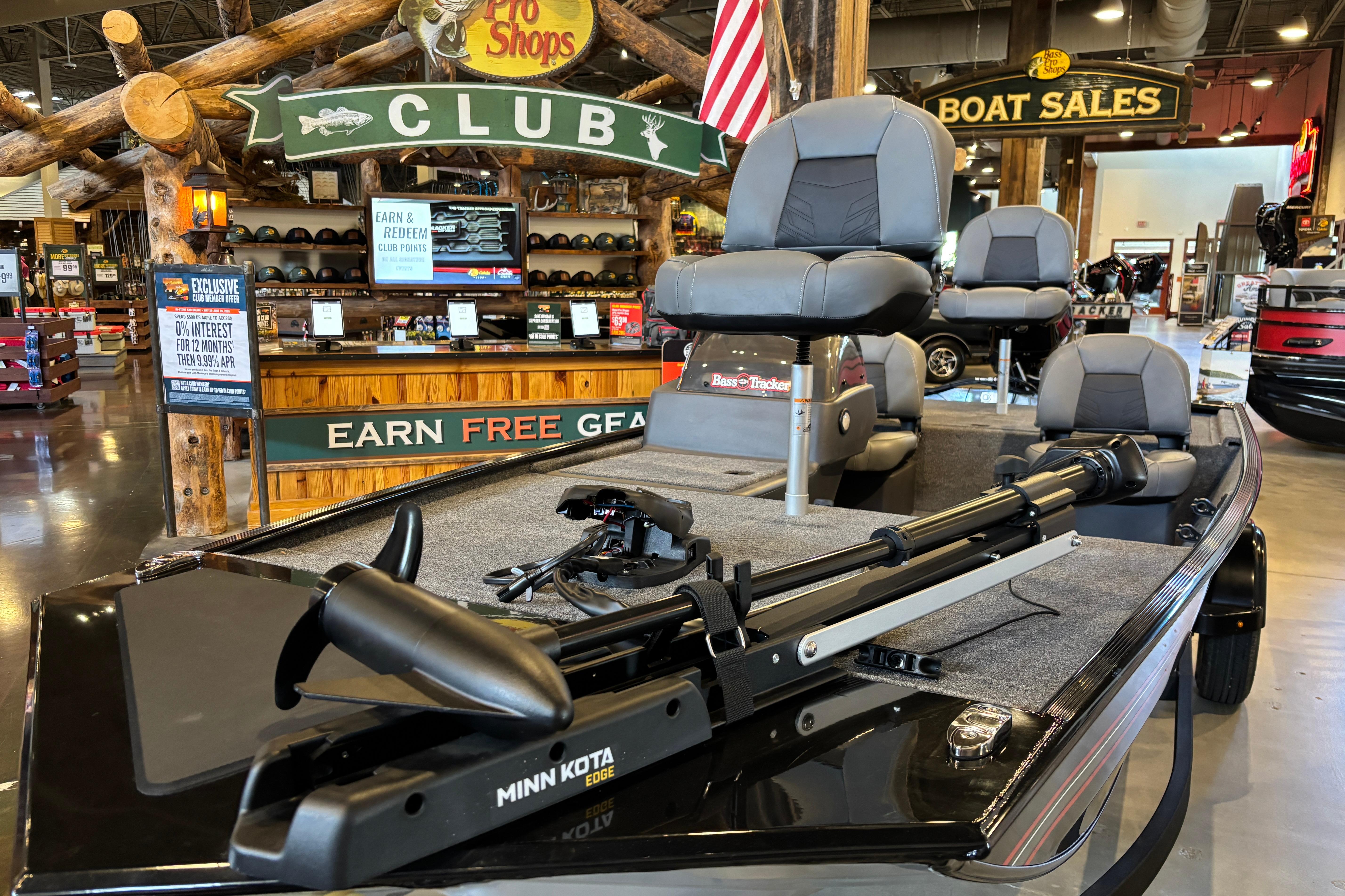 2026 Tracker Bass Tracker Classic XL boat displayed at a showroom with promotional signage.