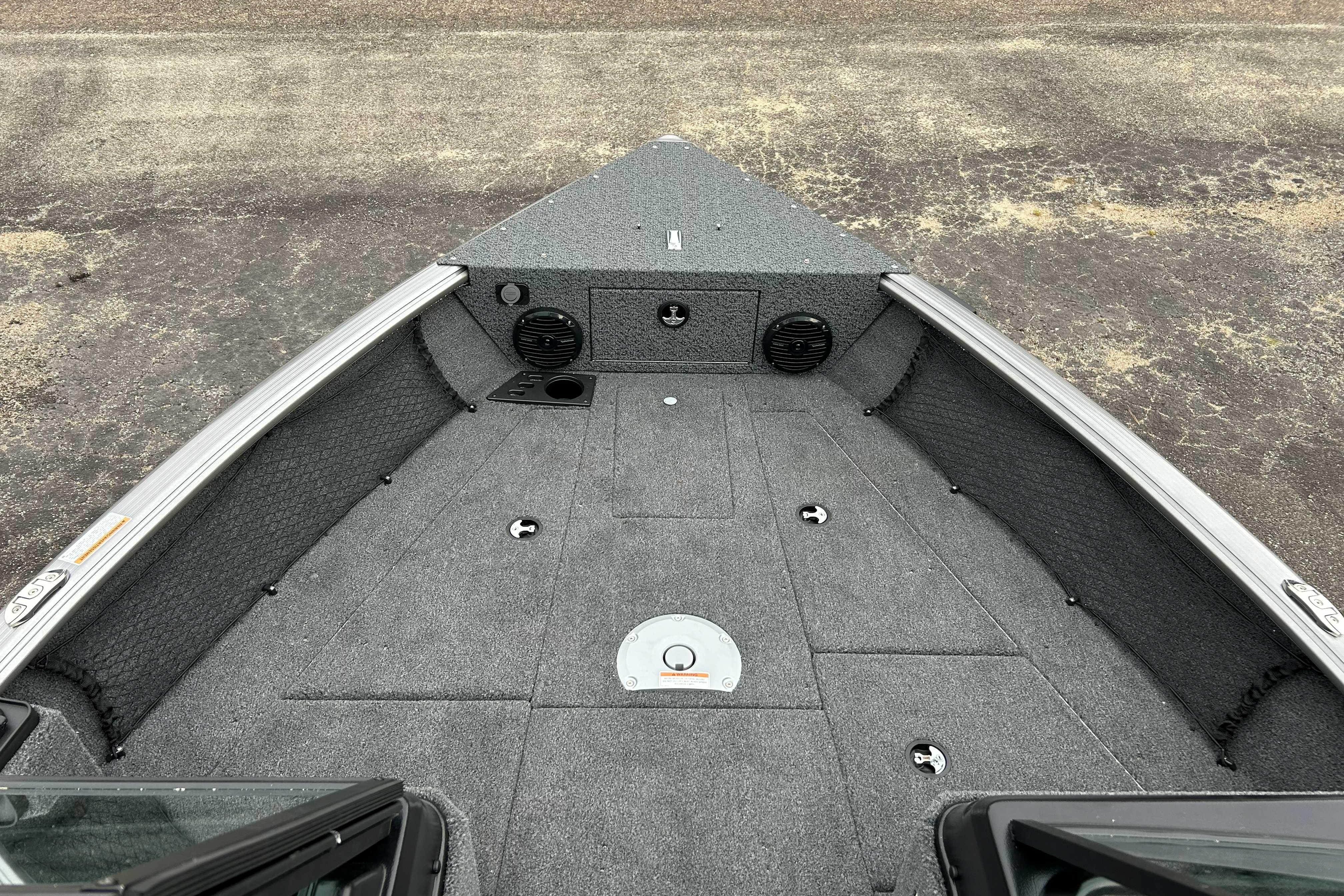 2027 Lund 1775 Impact XS boat interior with carpeted deck and storage compartments.