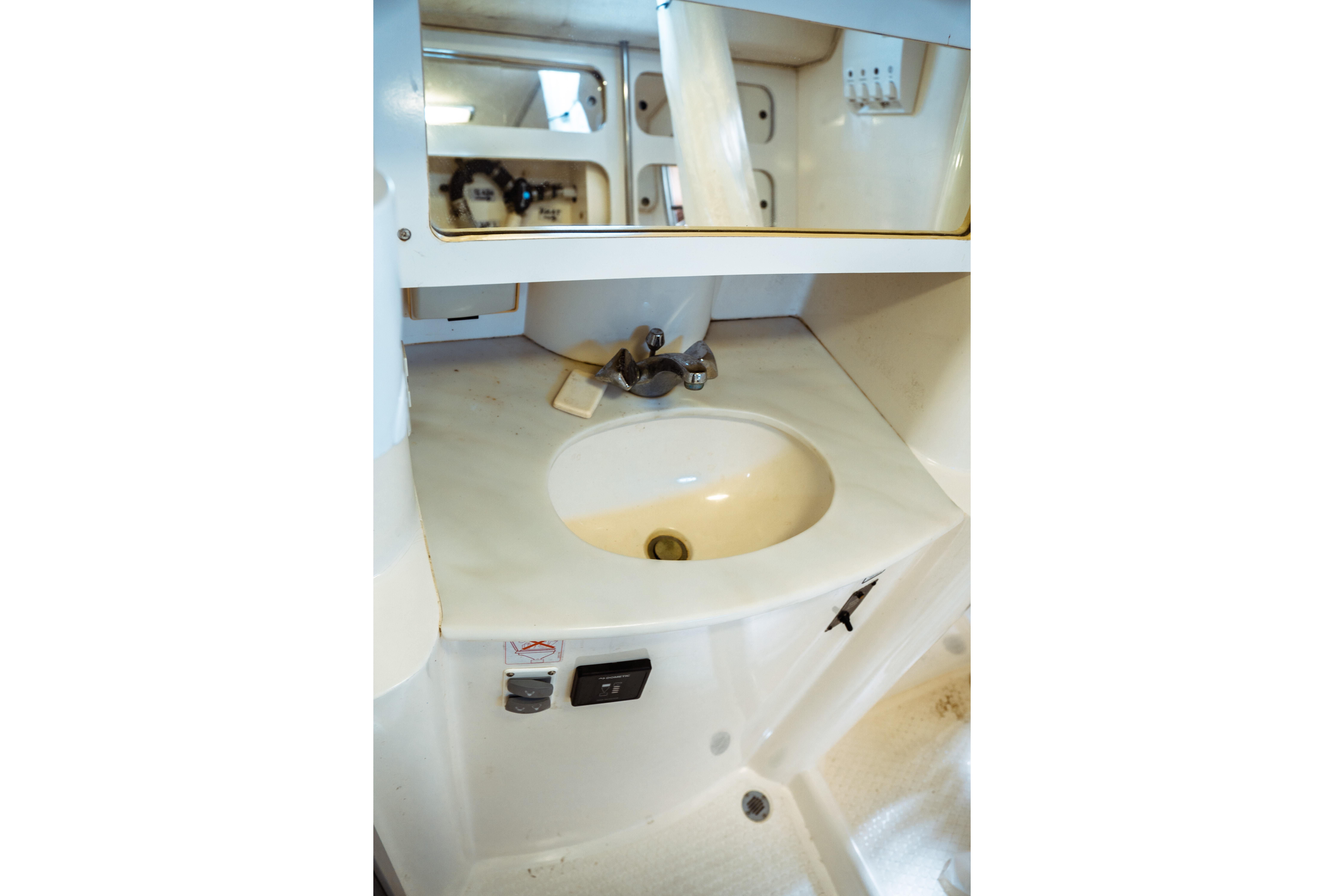 1994 Catalina 38 CC yacht bathroom sink with mirror and storage.