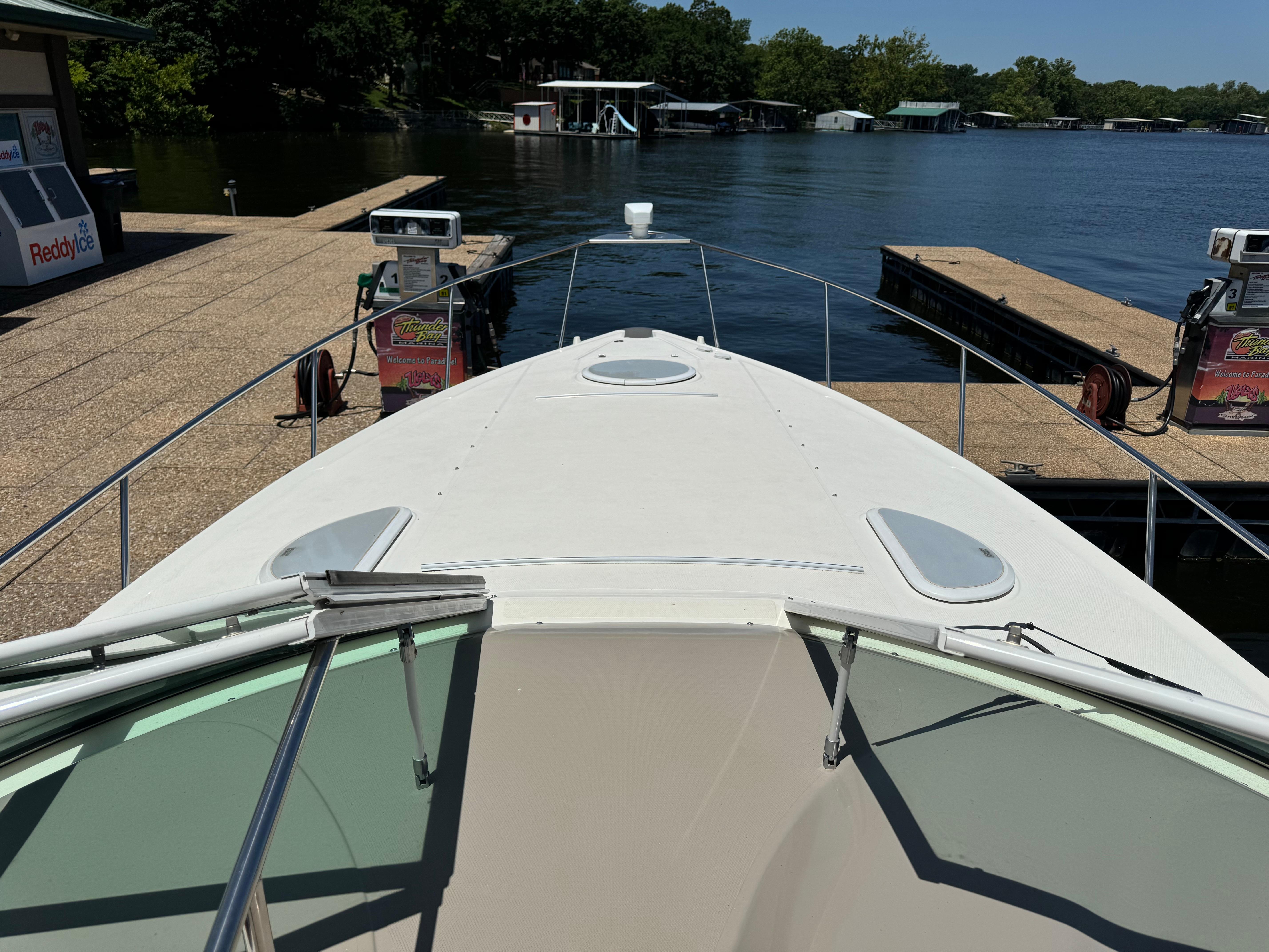 2004 Cruisers Yachts 320 Express docked at a marina with clear water view.
