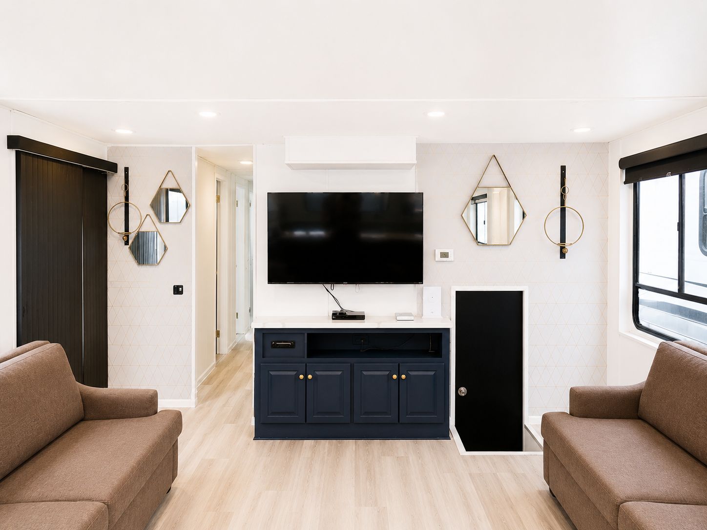 Interior of a houseboat with modern furnishings and a wall-mounted TV.