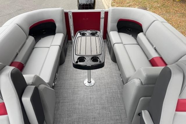 2026 Sun Tracker Party Barge 22 DLX interior with gray and red seating, central table.