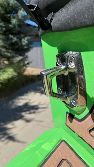 Close-up of a green boat part with a metal handle.