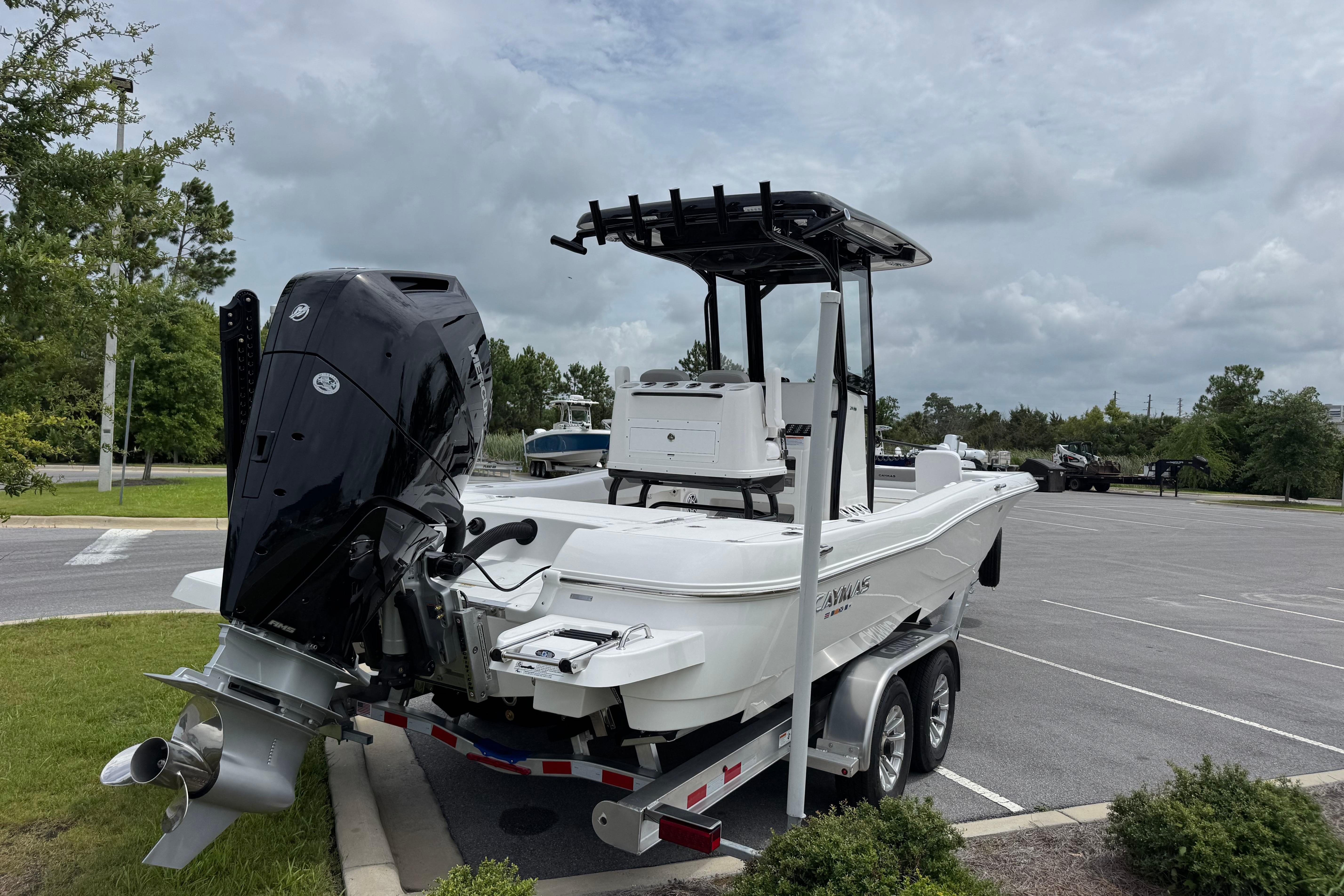 2027 Caymas 26 HB boat on trailer, parked outdoors under cloudy sky.
