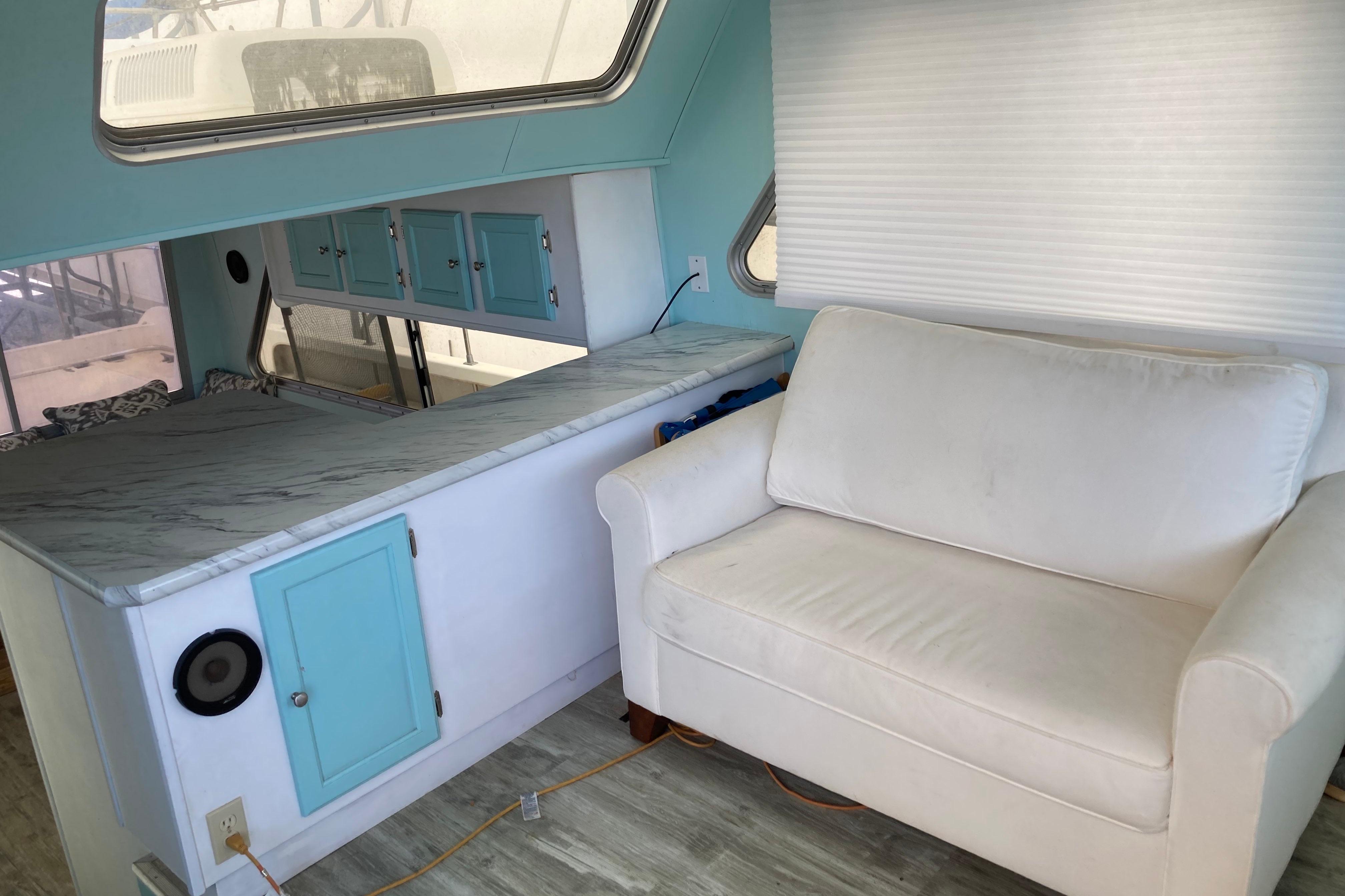 Interior of a 1992 Holiday Mansion 40 with white sofa and turquoise cabinets.