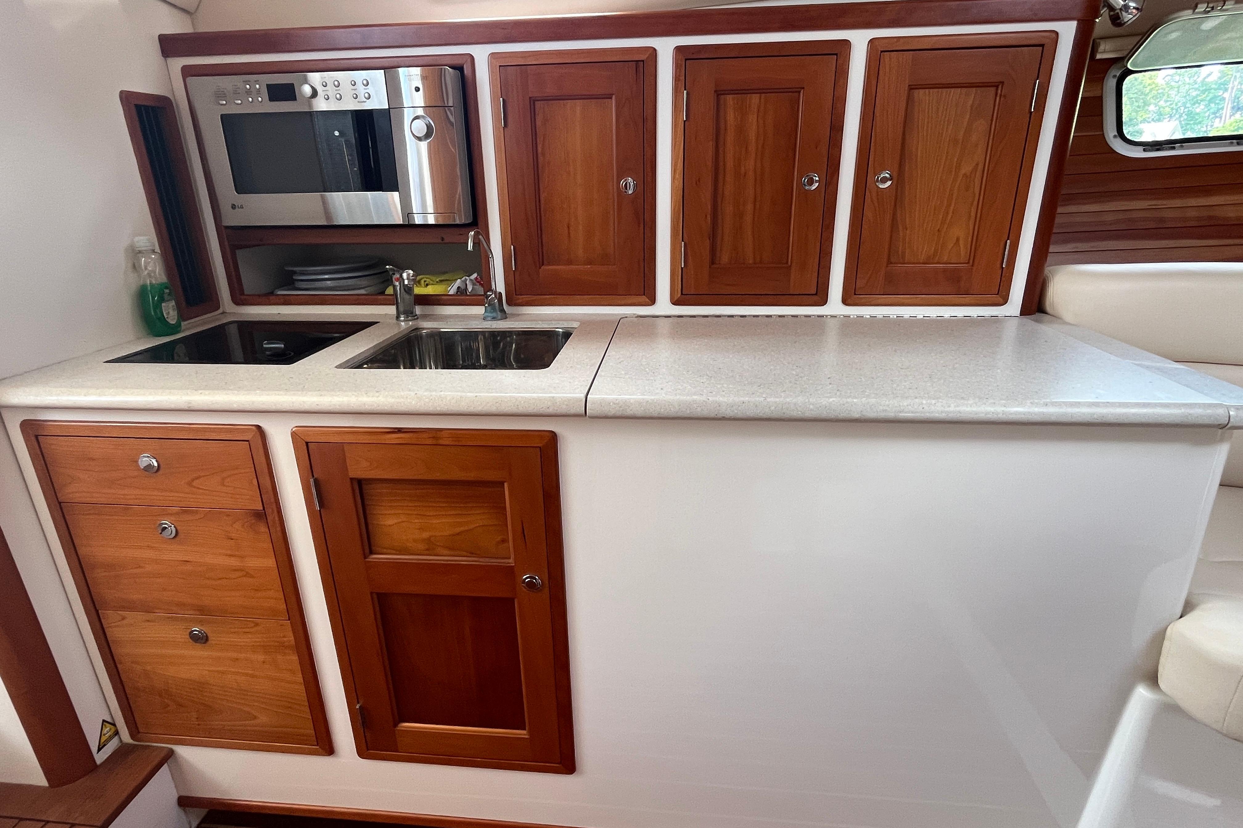 2006 MJM 34z yacht kitchen with wooden cabinets, sink, and microwave.