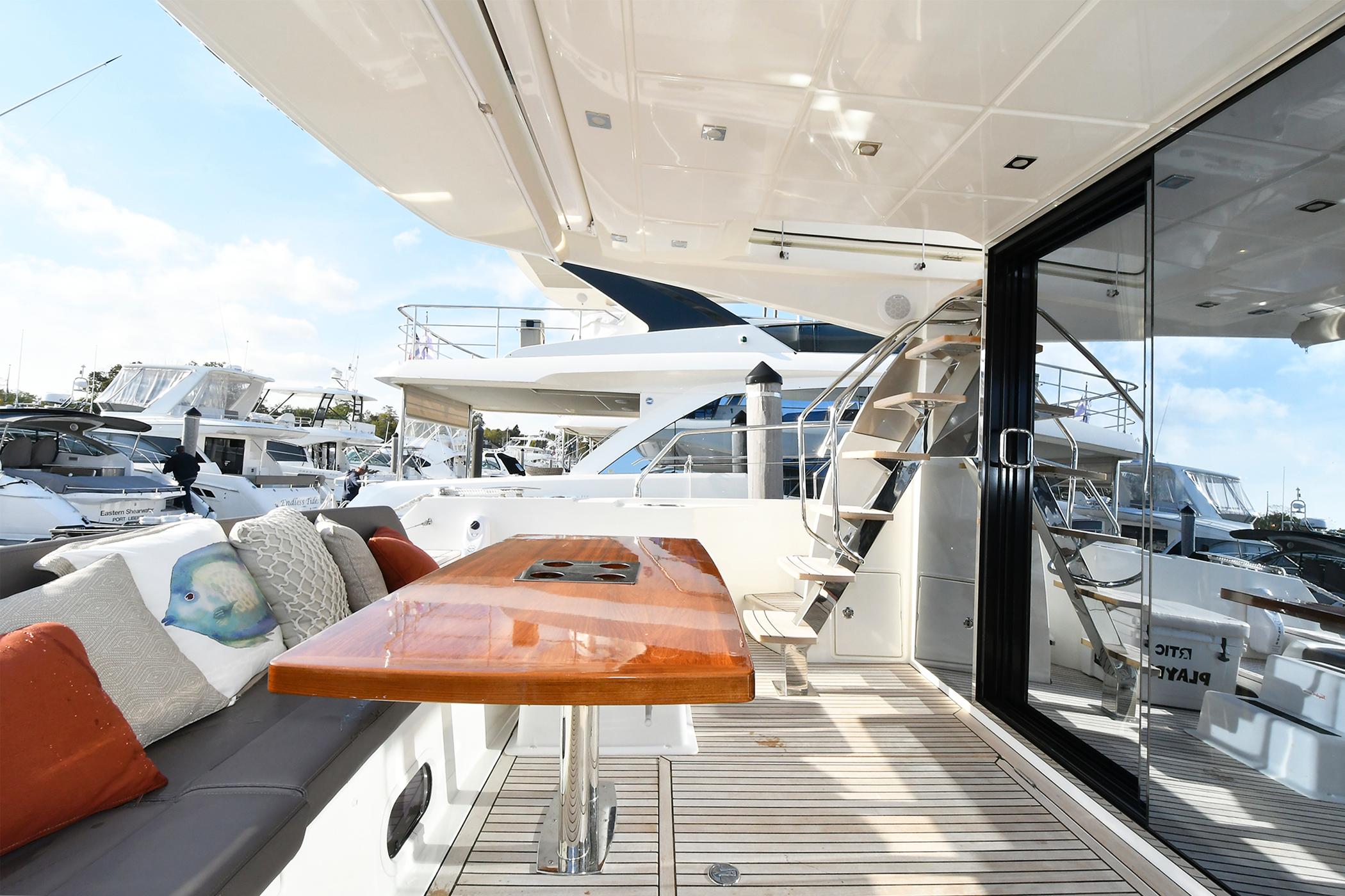 Luxurious 2018 Prestige 560 Fly yacht deck with seating, table, and staircase.