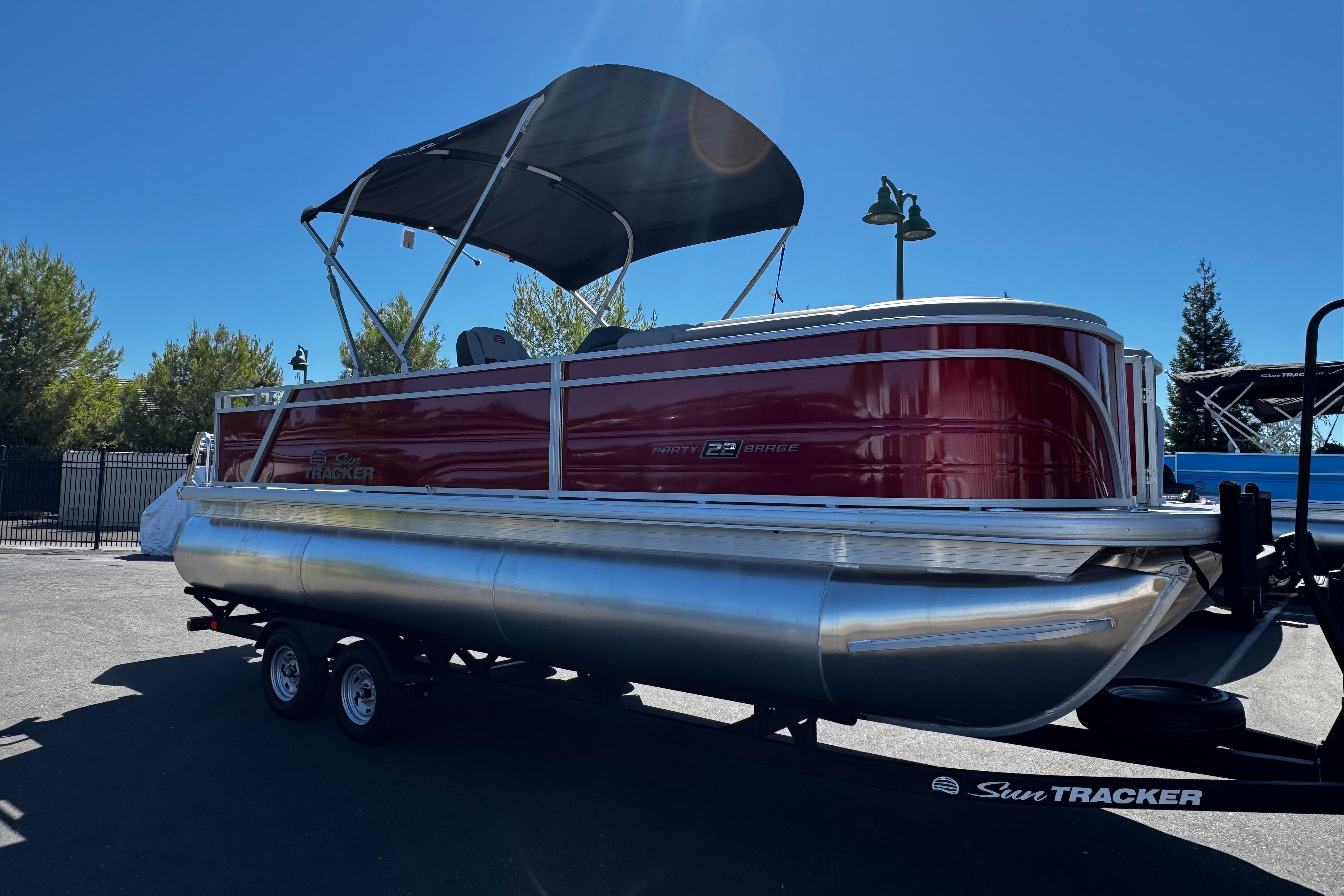 2026 Sun Tracker Party Barge 22 XP3 pontoon boat with canopy on trailer.