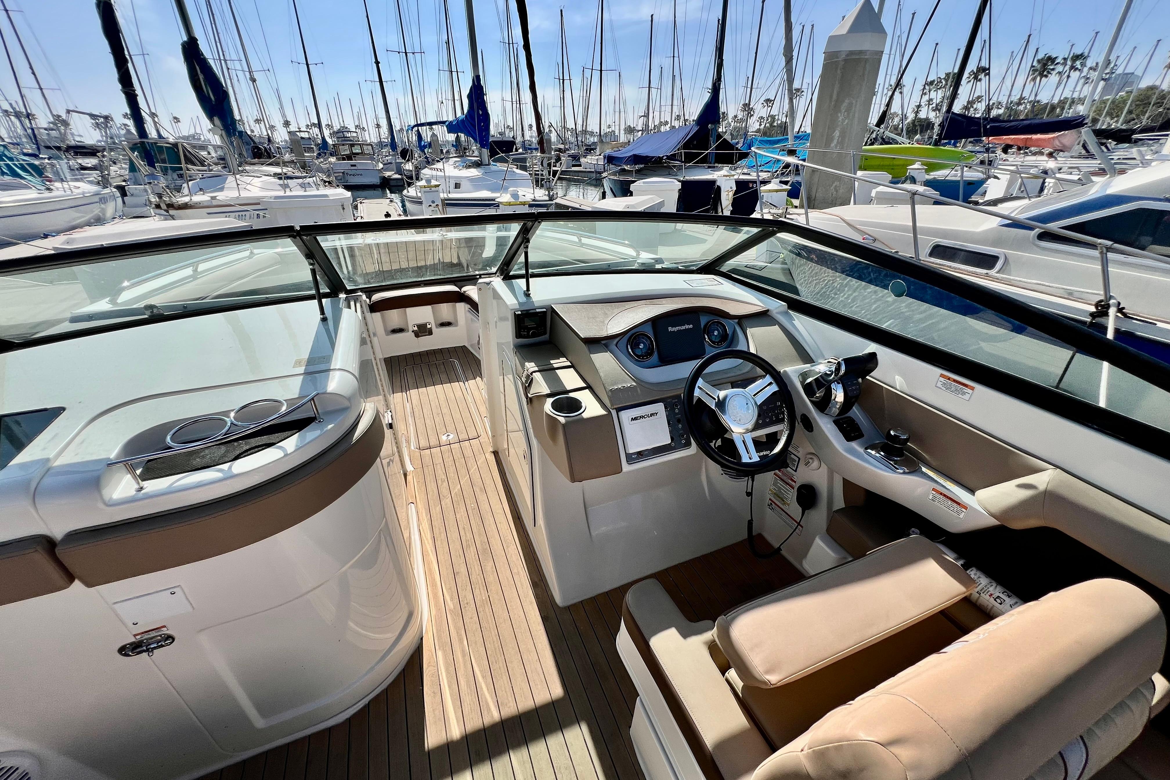 2016 Sea Ray 290 Sundeck Outboard boat interior with helm, docked at marina.