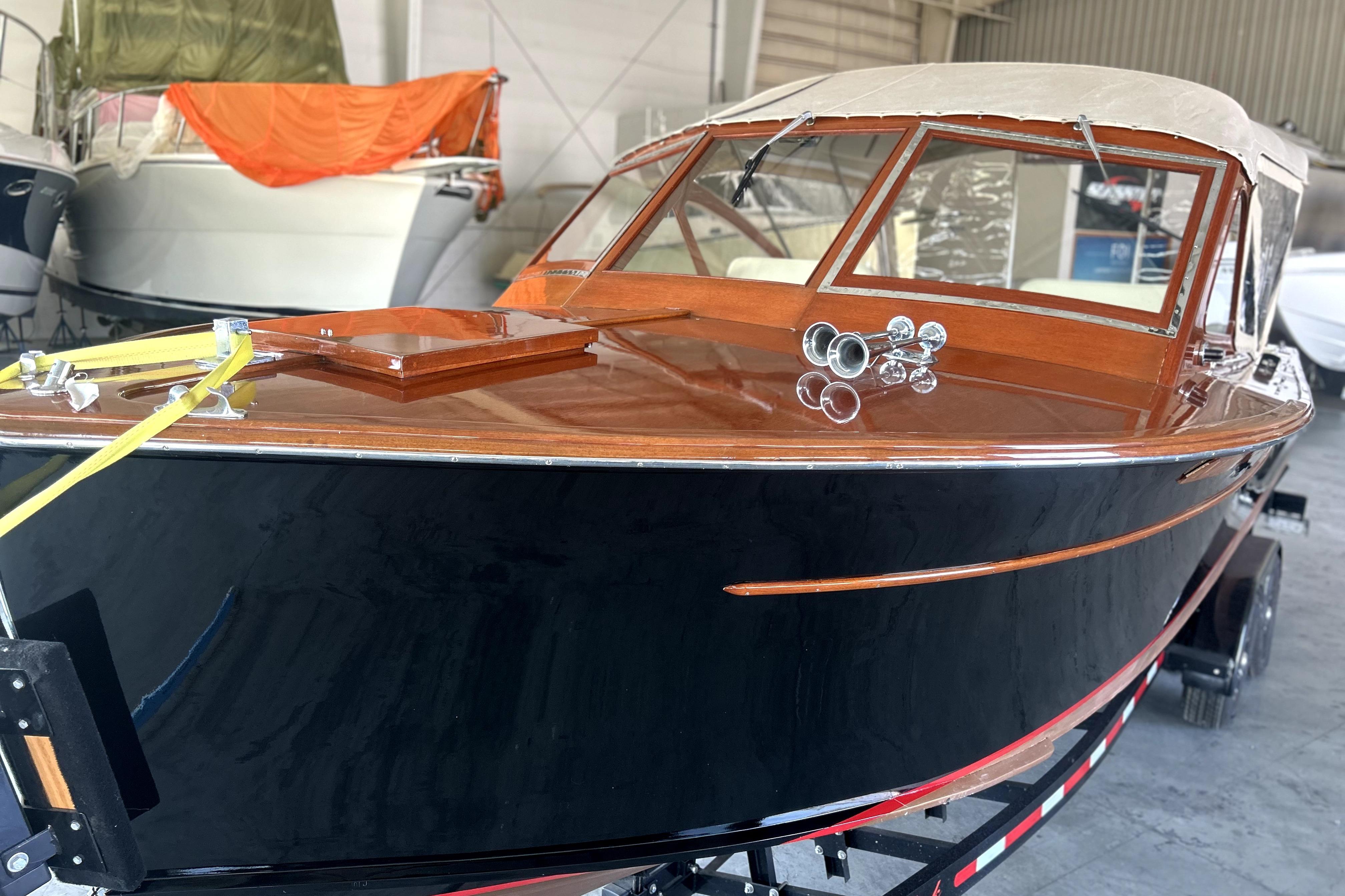 1962 Prowler Forest Johnson boat with polished wood finish in a storage facility.