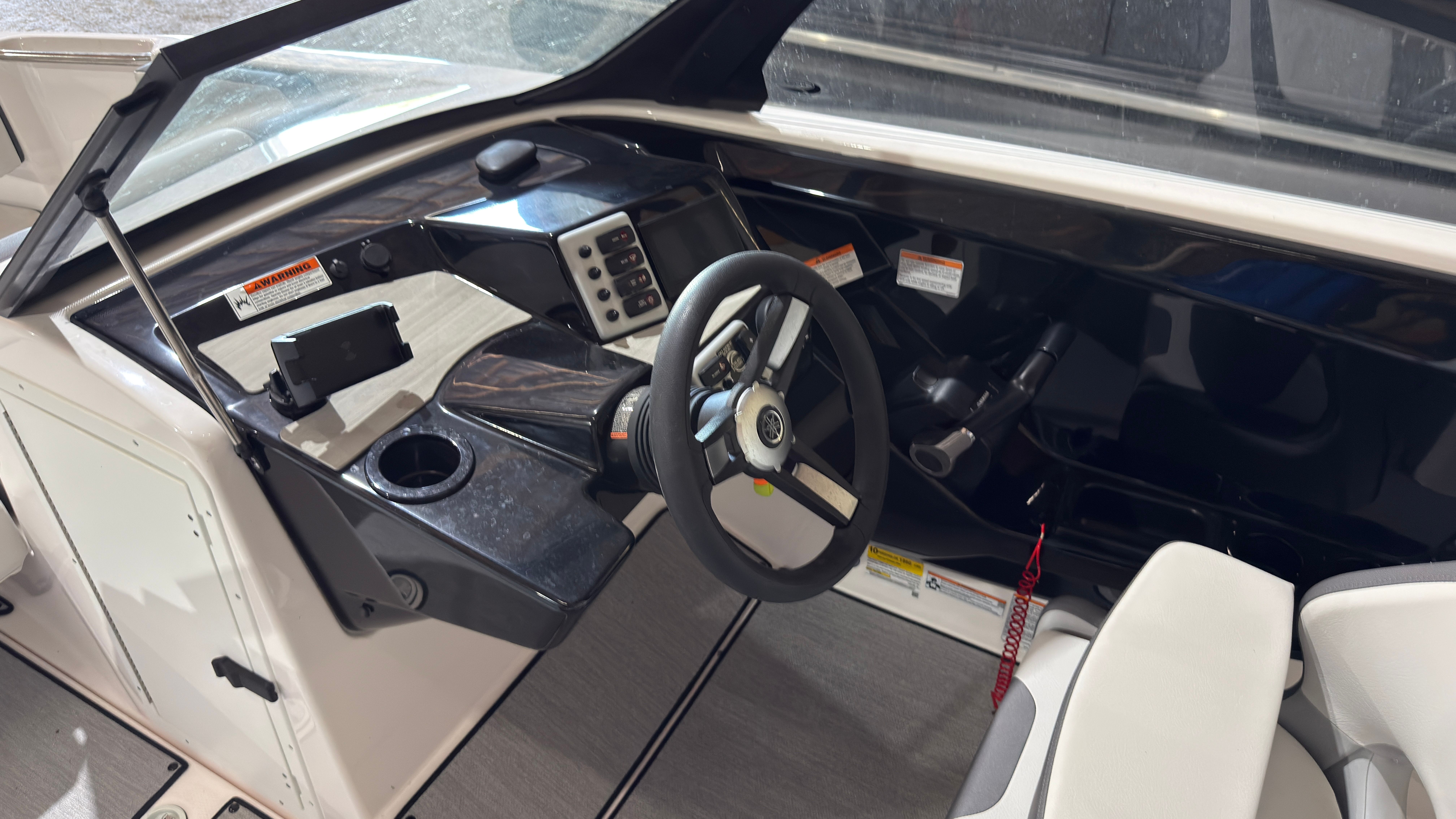 Interior of 2024 Yamaha AR220 boat with steering console.