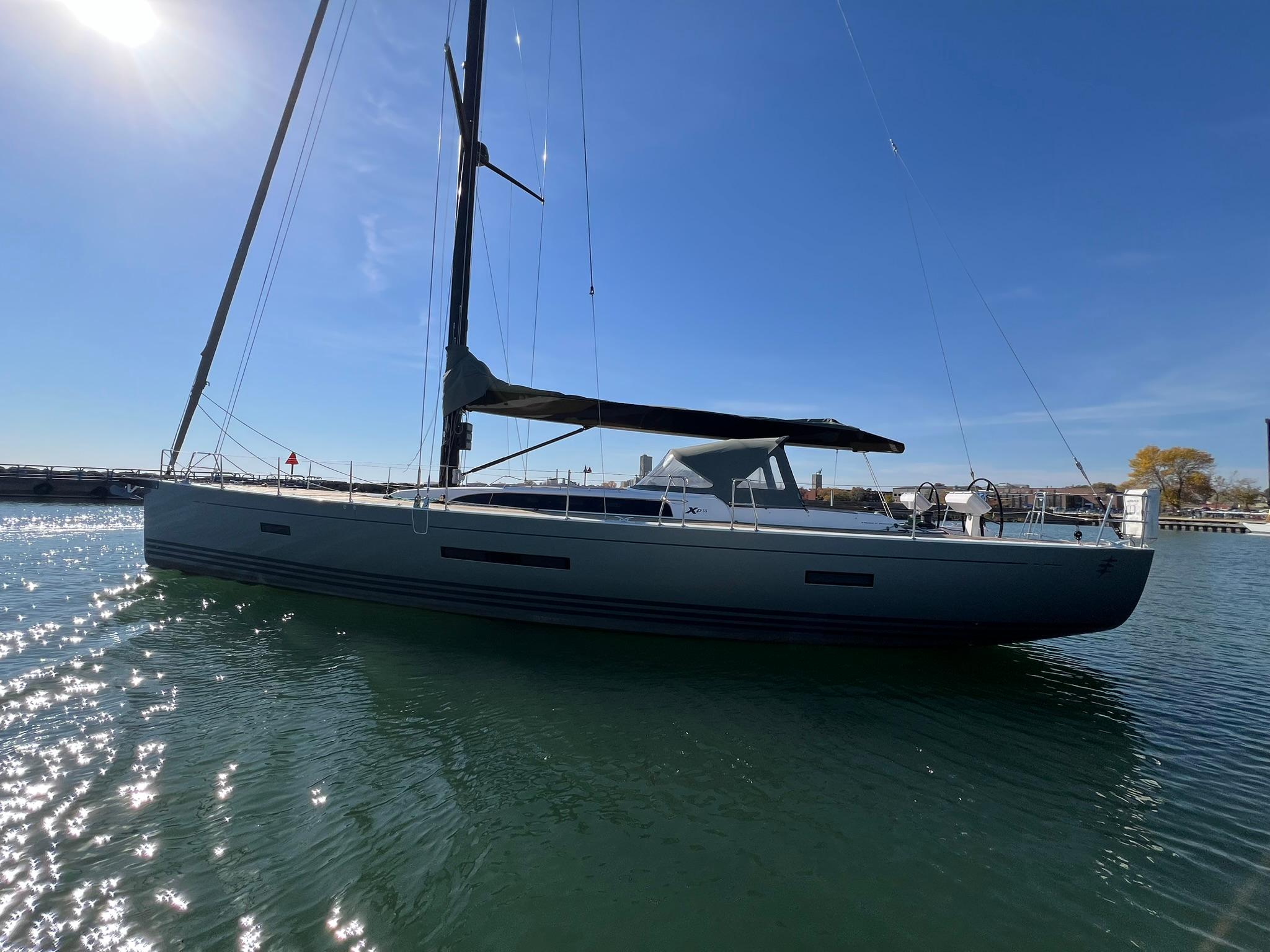 2015 X-Yachts Xp 55 sailboat on calm water under clear blue sky.