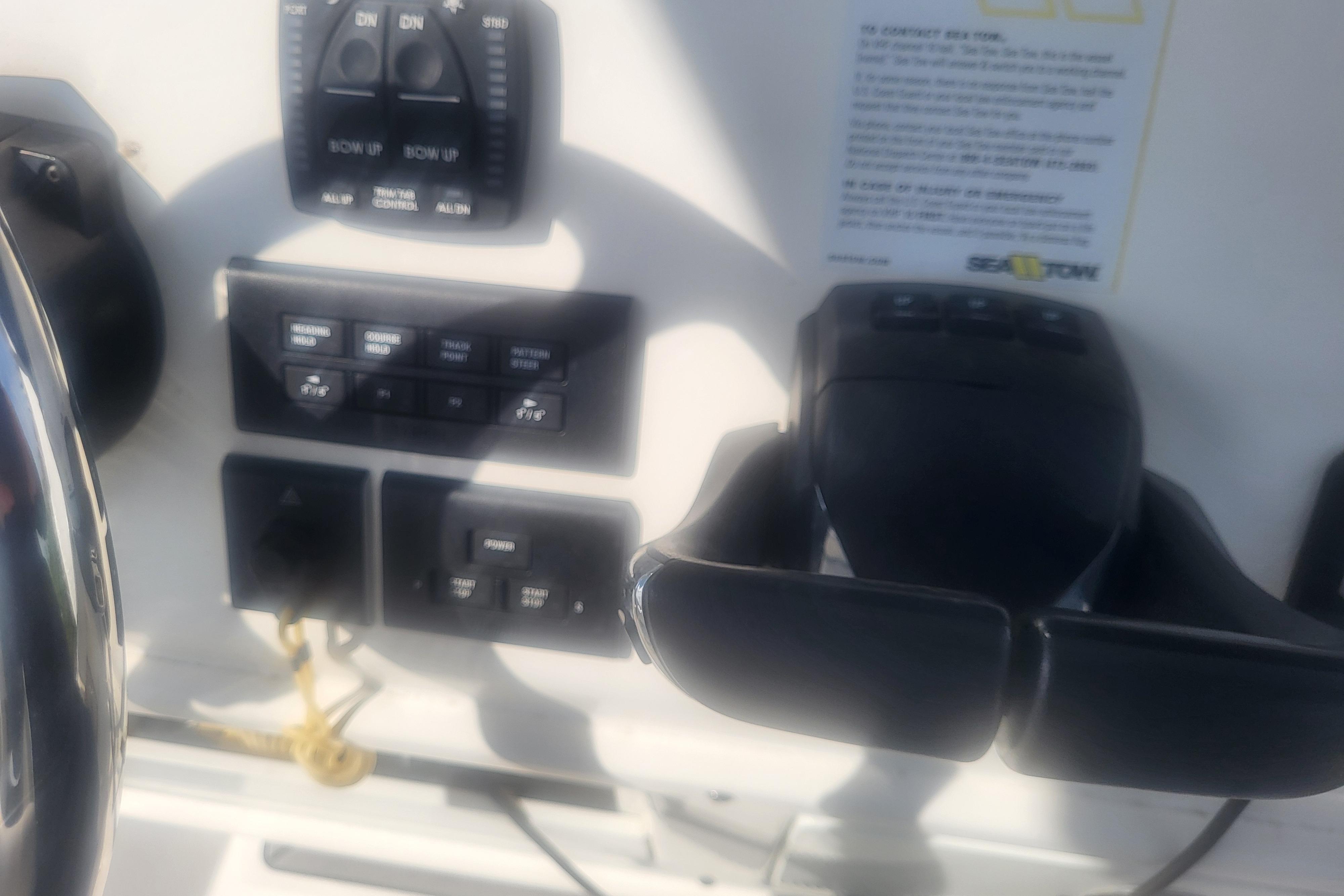 Control panel of 2022 Cobia 262 Center Console boat with various switches and levers.