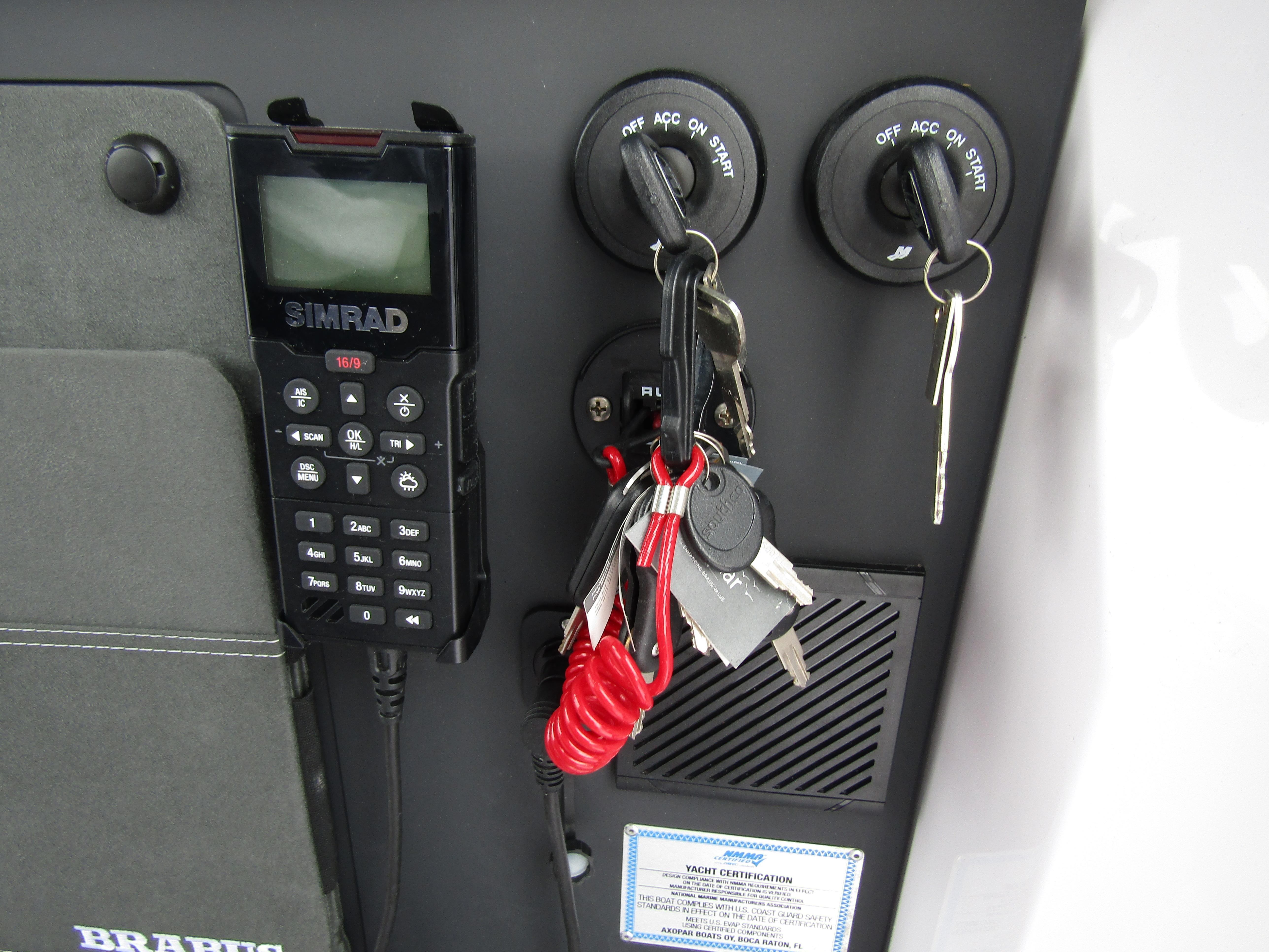 Control panel with keys and SIMRAD device on 2024 Axopar 37 Sun Top boat.