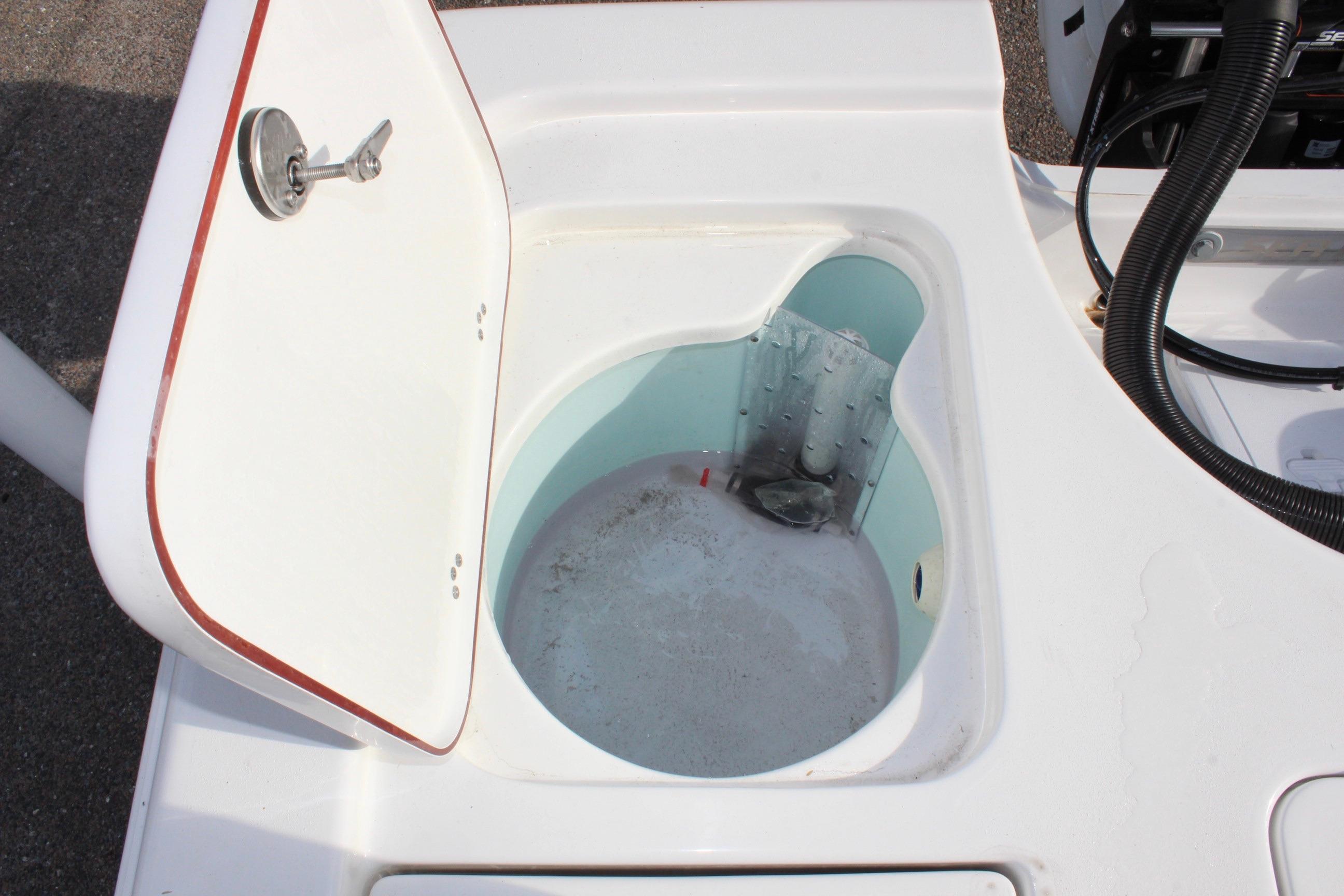 Open storage compartment on 2025 Sea Pro 230 Bay boat, featuring a circular design.
