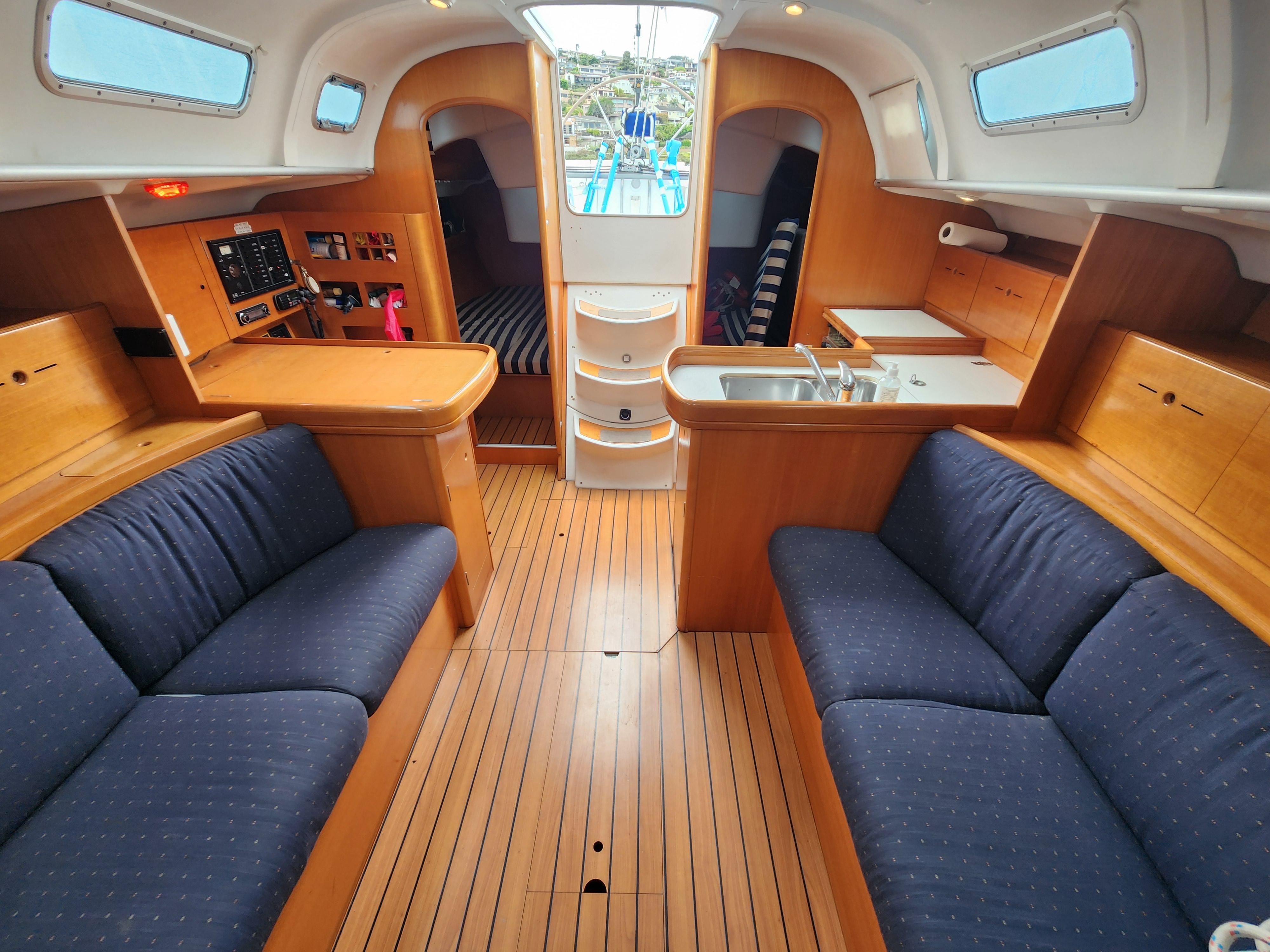 Interior of 2003 Beneteau First 40.7 sailboat with wood finish and blue seating.