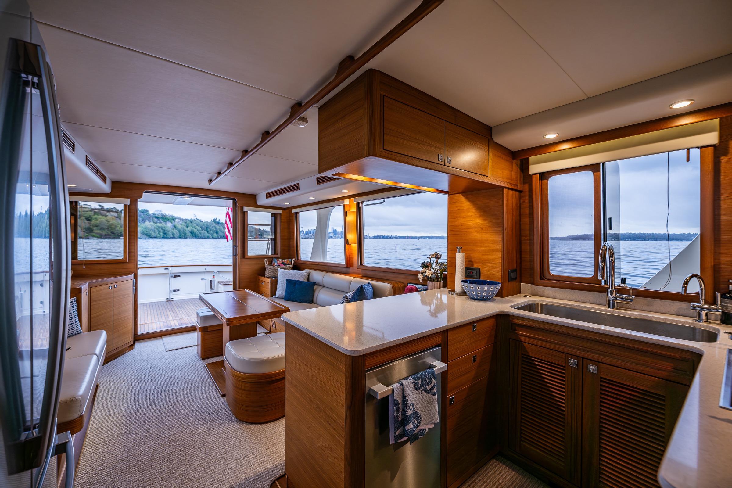 Luxurious interior of 2026 Fleming 55 Pilothouse yacht with modern kitchen and scenic water views.