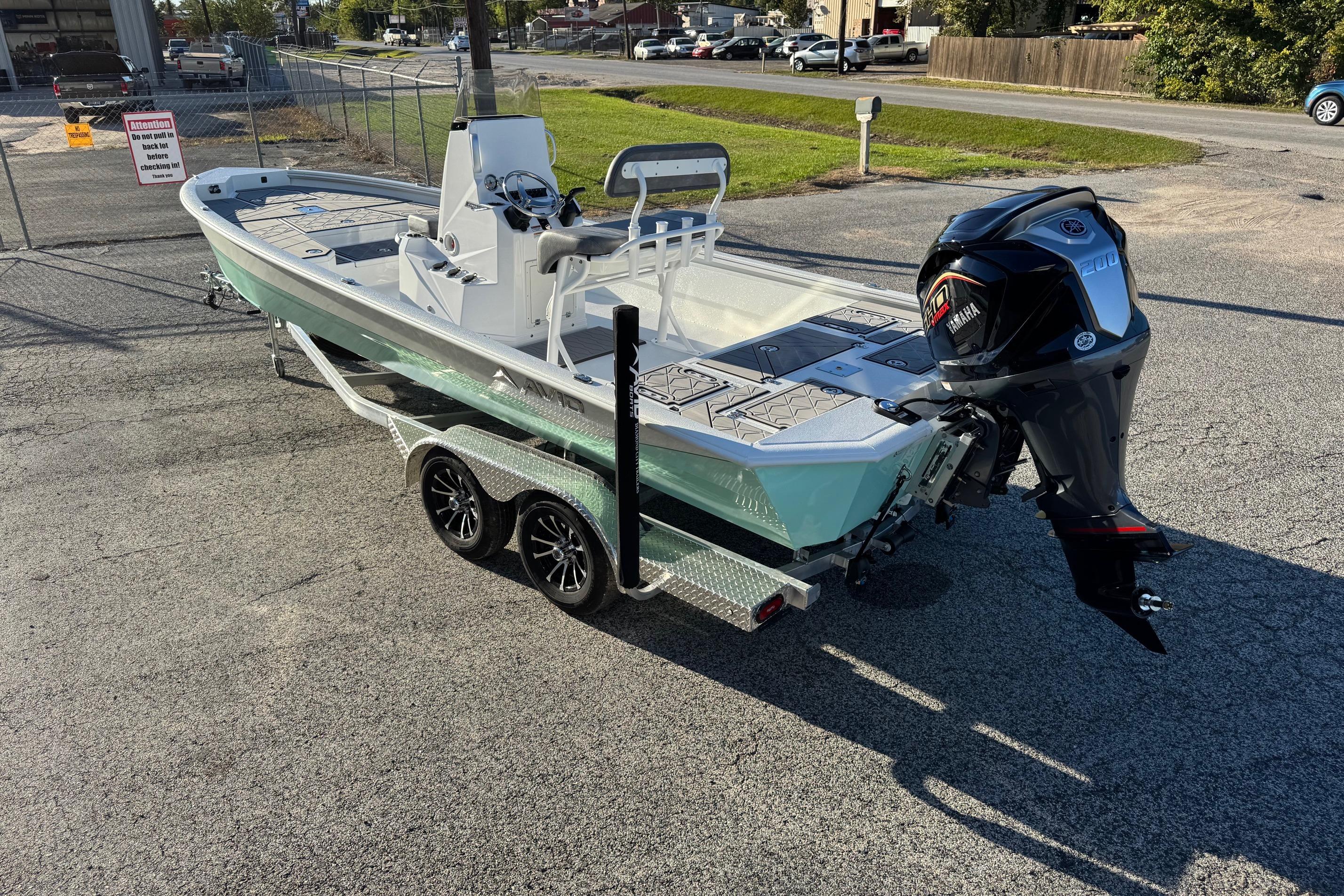 2025 Avid 23 Mag boat on trailer with Yamaha outboard motor in parking lot.