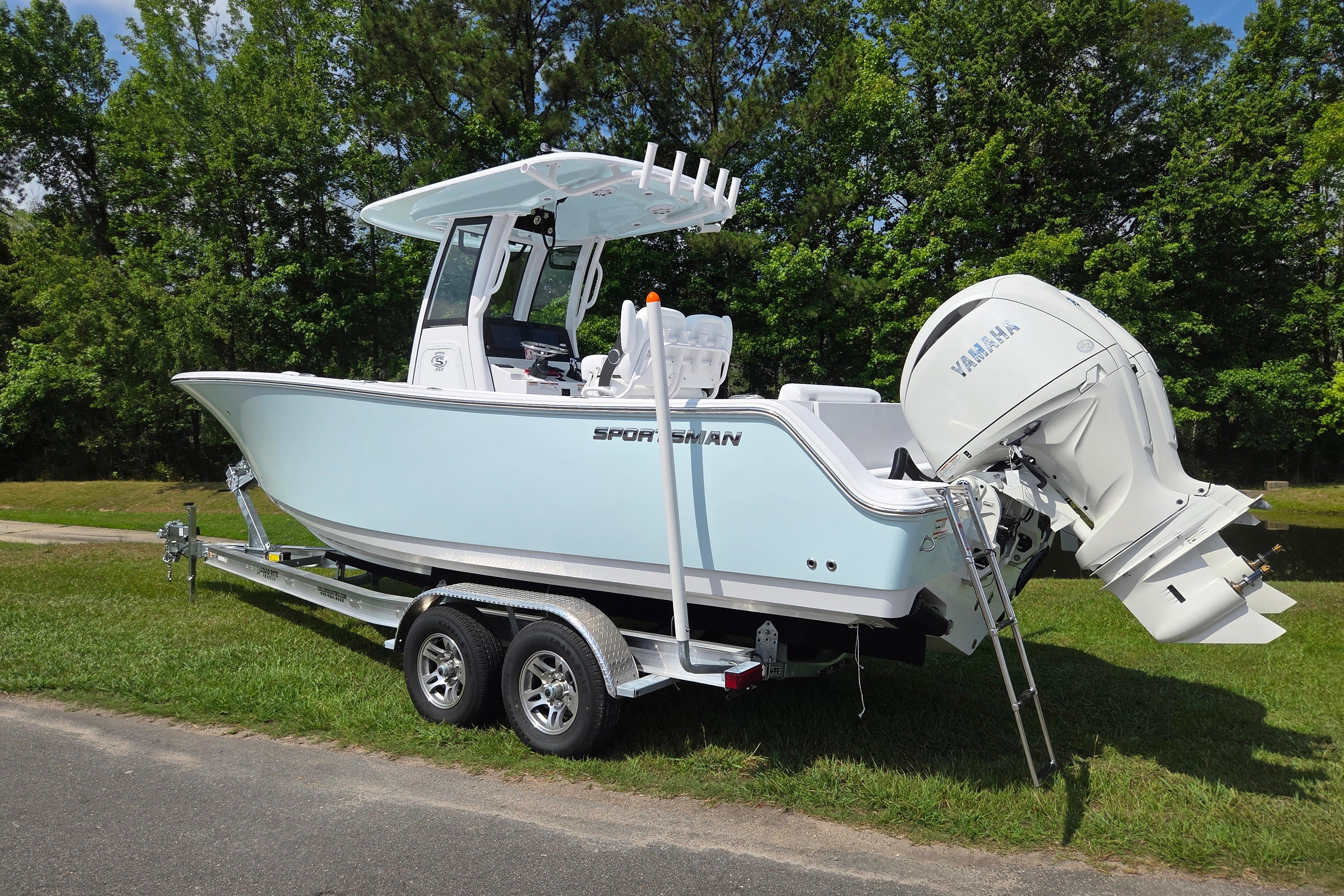 2026 Sportsman Open 252 Center Console boat on trailer, parked on grass.