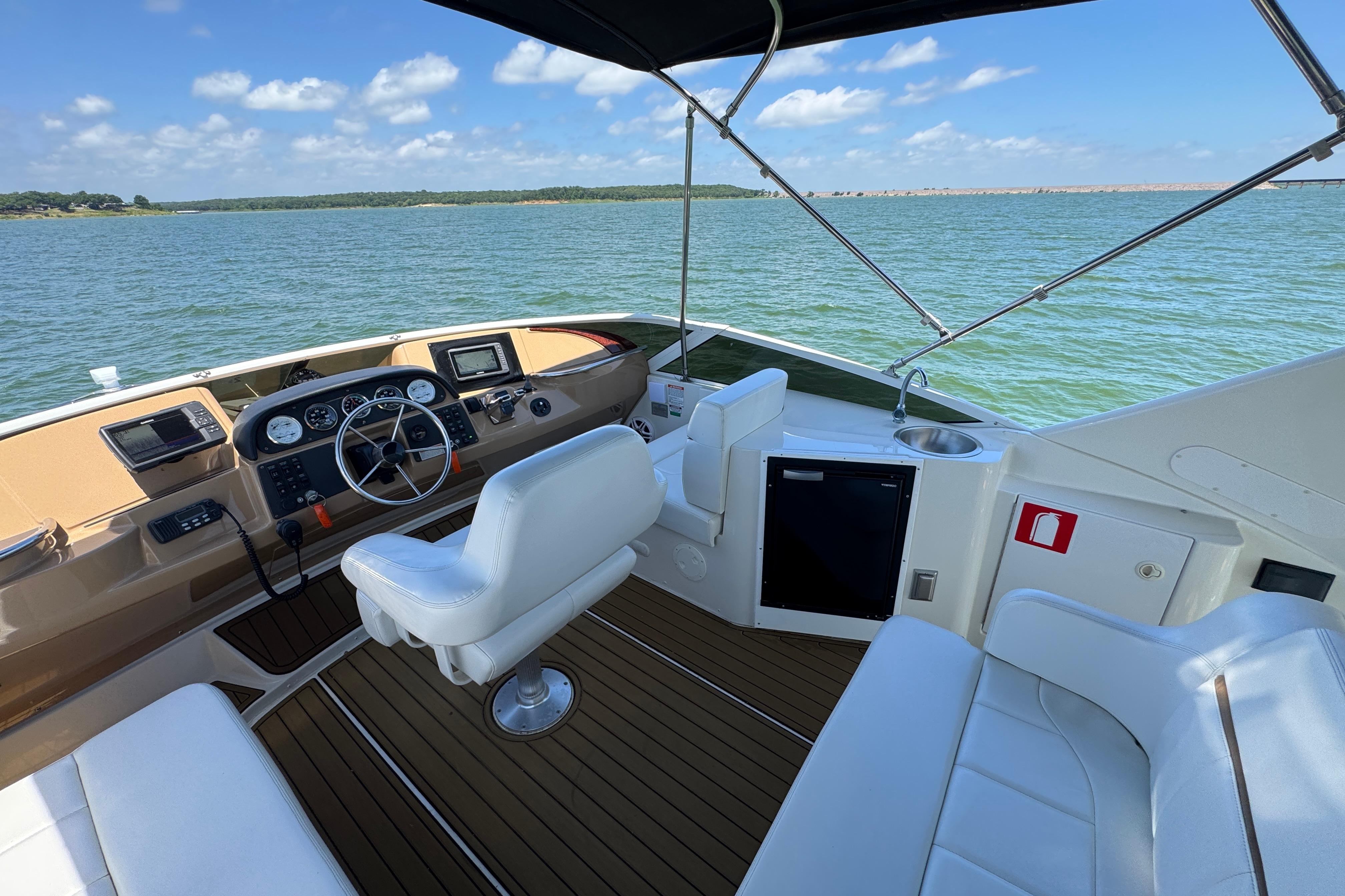 2002 Carver 396 Motor Yacht helm with white seating, overlooking serene waters.