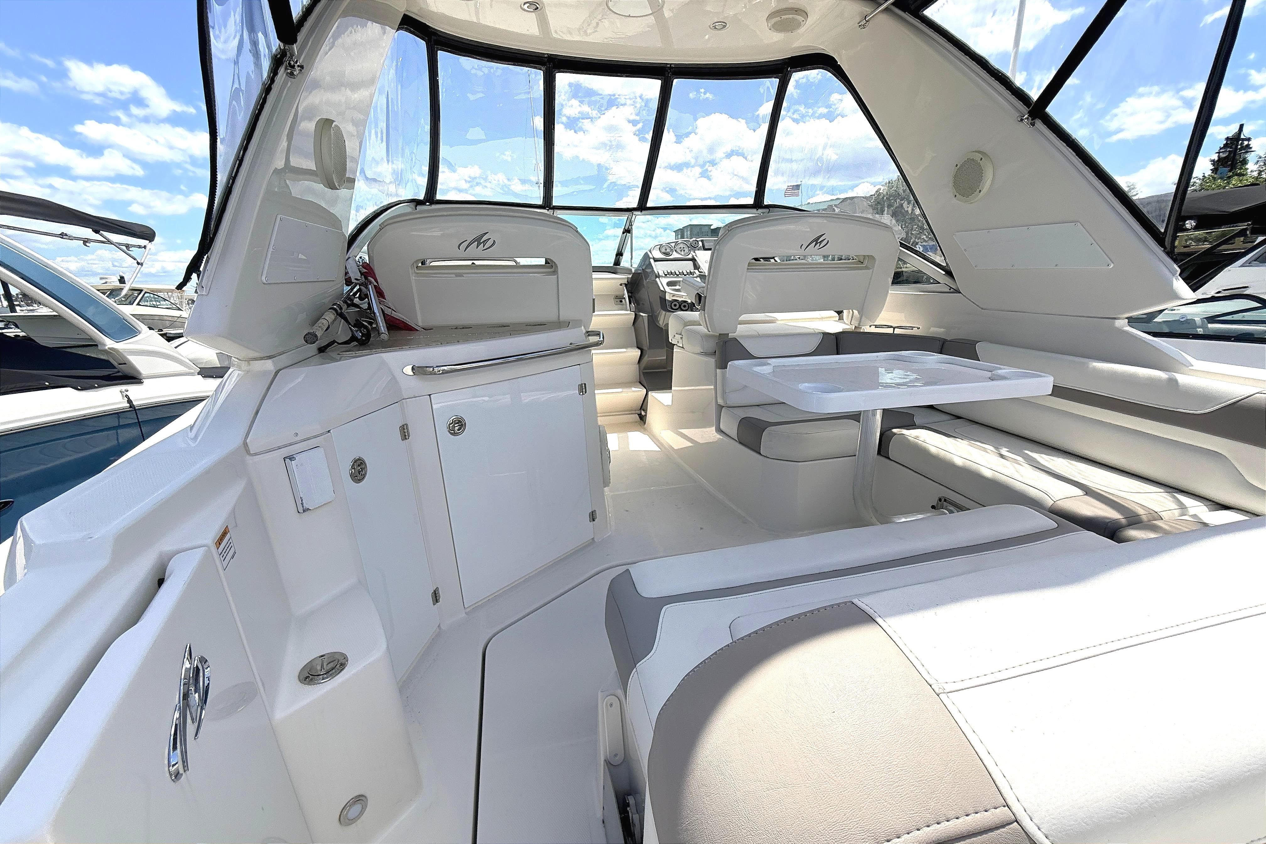 Interior of a Monterey 320 Sport Yacht with white seating and table.