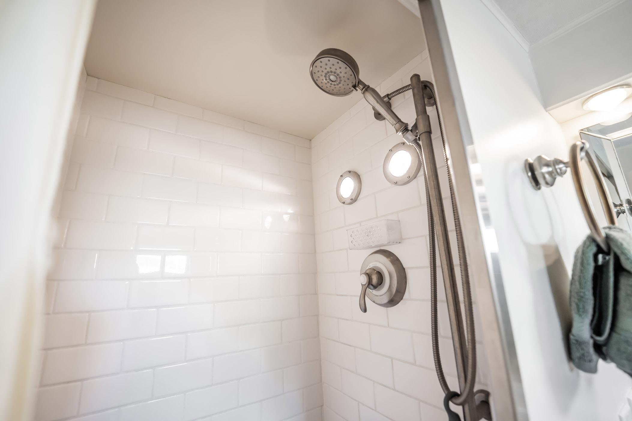 Shower area in 1972 Trumpy 72 Motor Yacht with white tiles and modern fixtures.