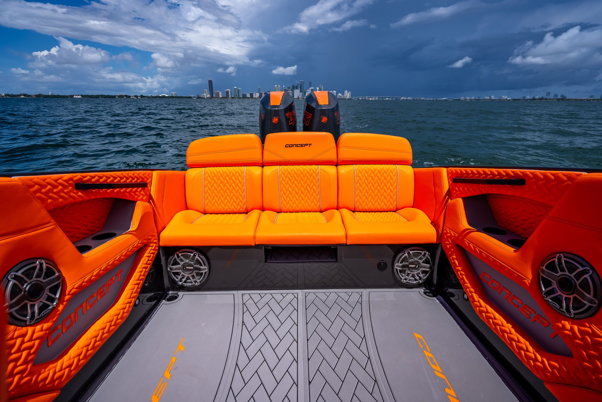 The image shows the bright orange interior of a Concept 32' Sport boat on the water.