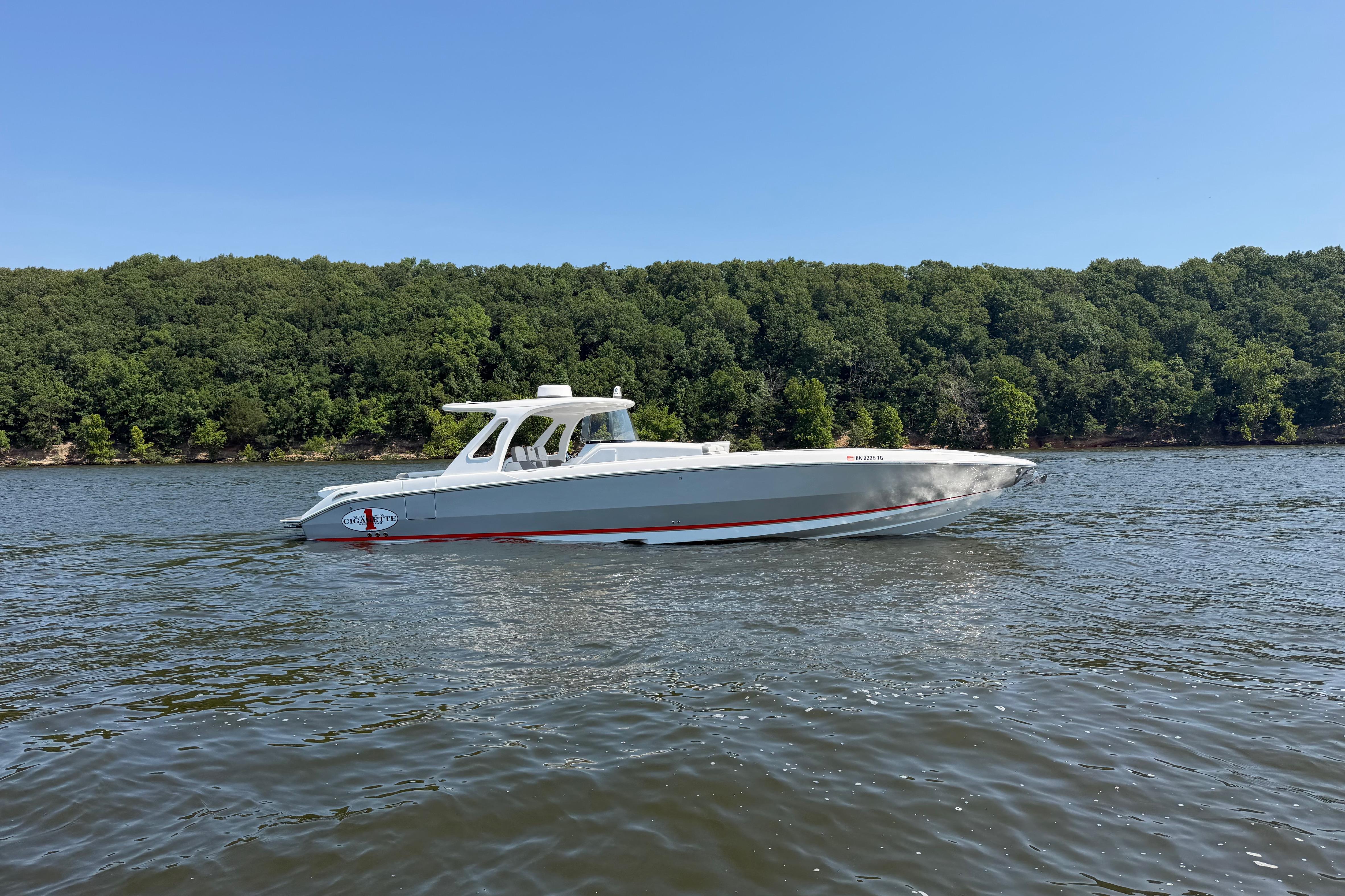 2015 Cigarette 41' Nighthawk SD Edition boat on a scenic lake with forested shoreline.