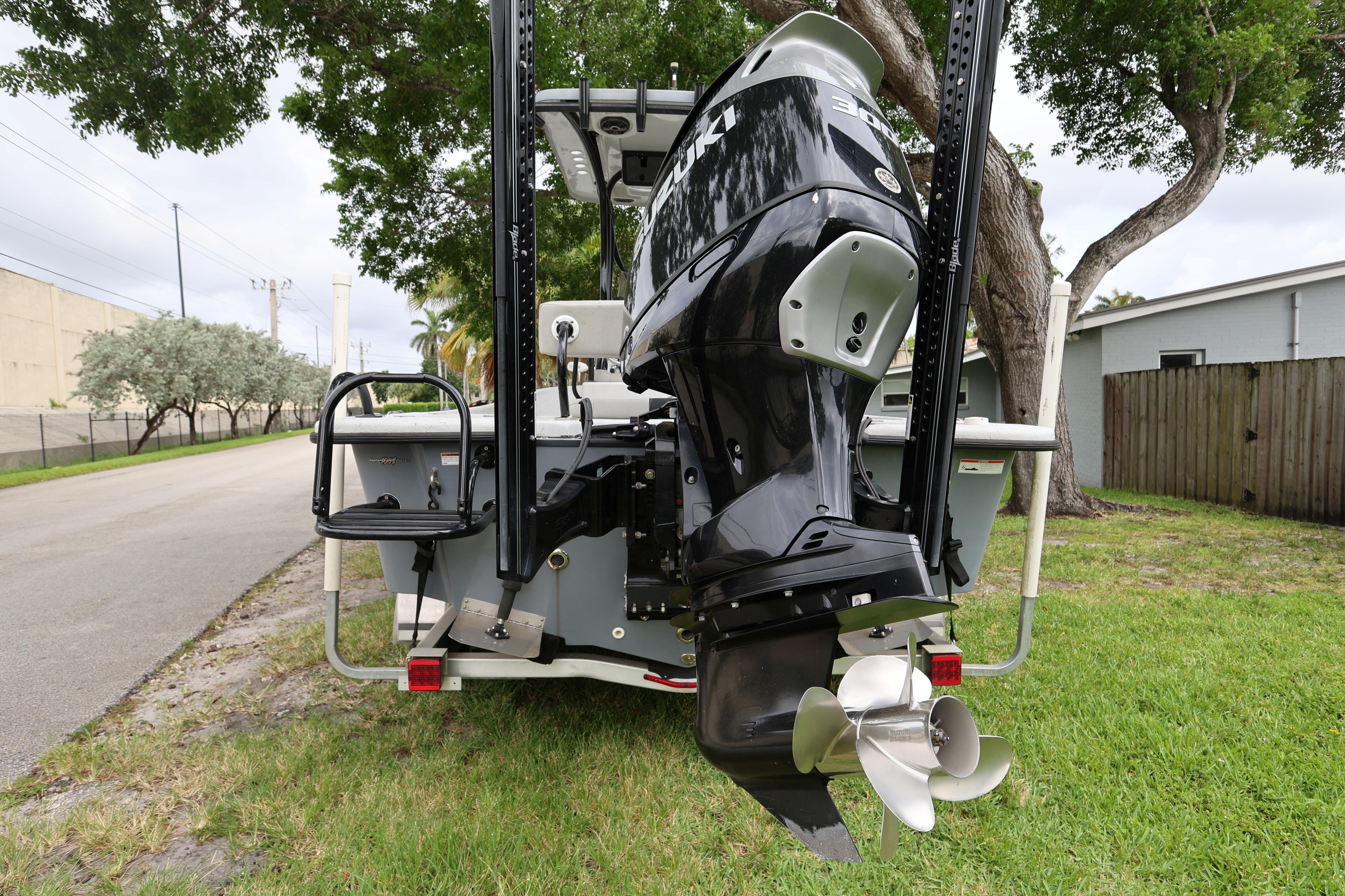 2021 Blazer Bay 2400 boat with powerful outboard motor, parked on grass.
