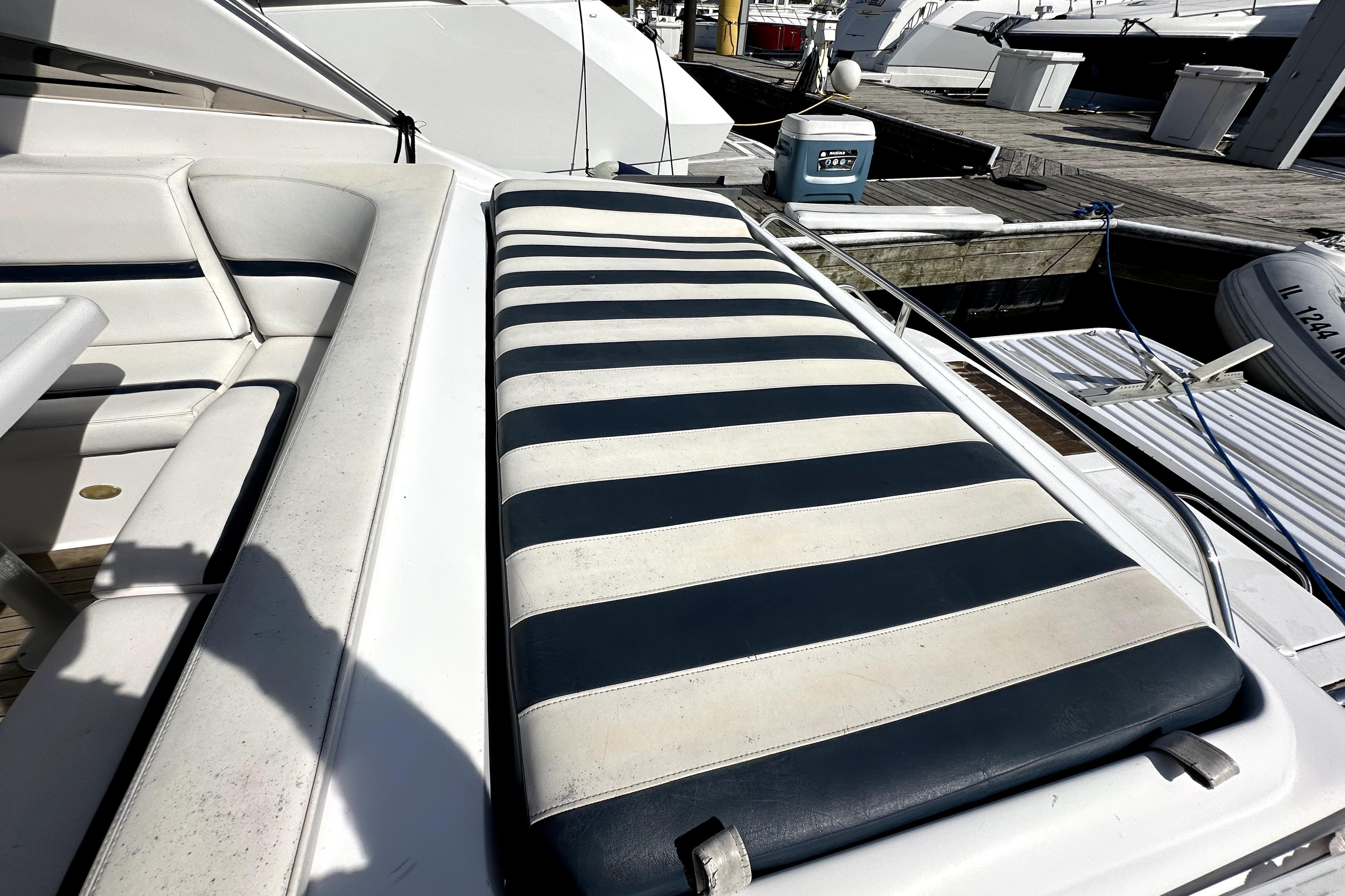 2003 Donzi 39 ZSC boat with striped sunbed and seating at marina.