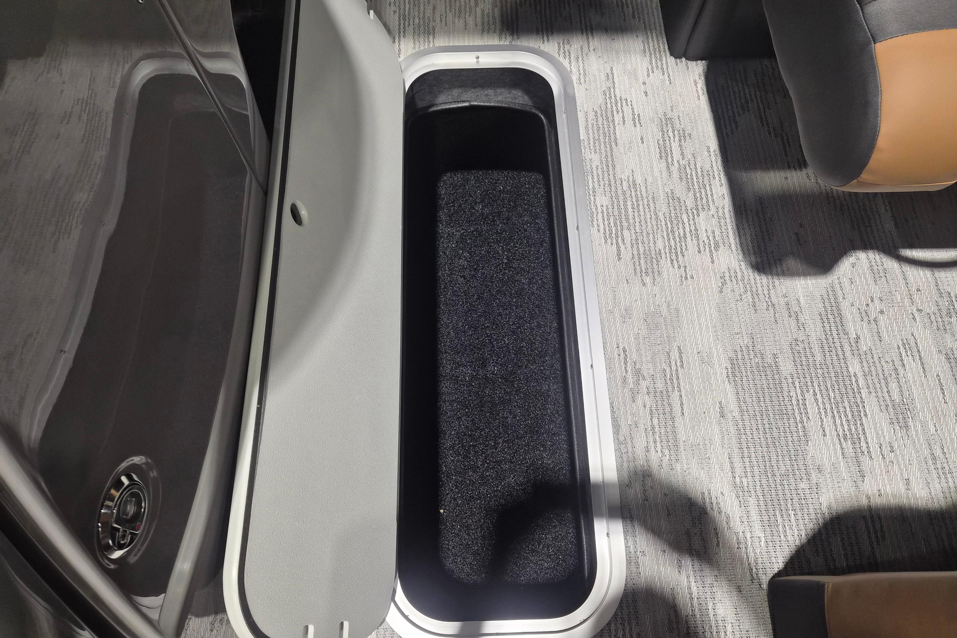 Open storage compartment in 2026 Sylvan L3 SLZ boat, featuring carpeted interior and sleek design.