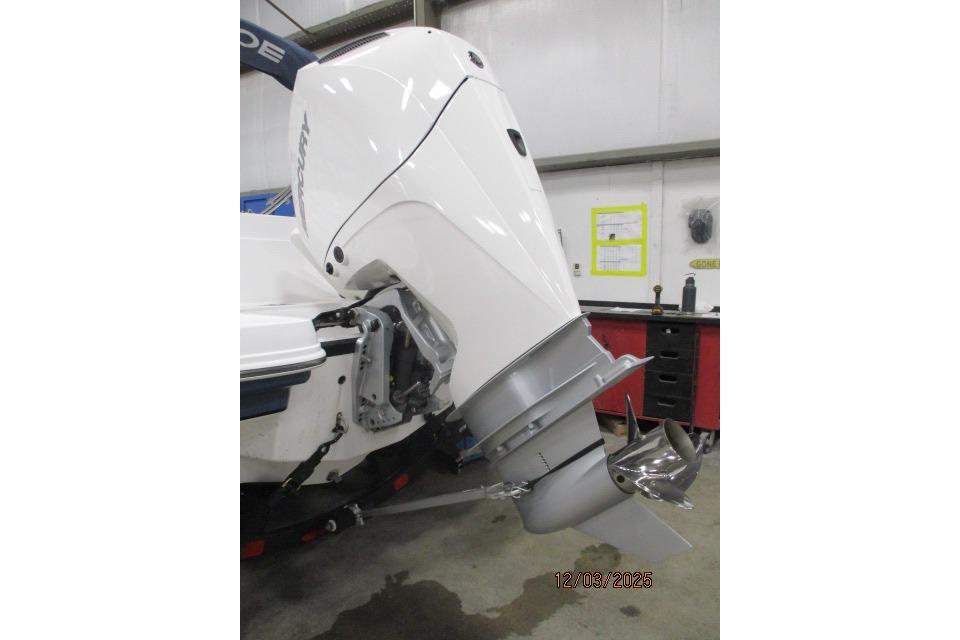 2024 Tahoe 2150 CC boat with Mercury outboard motor in a workshop setting.