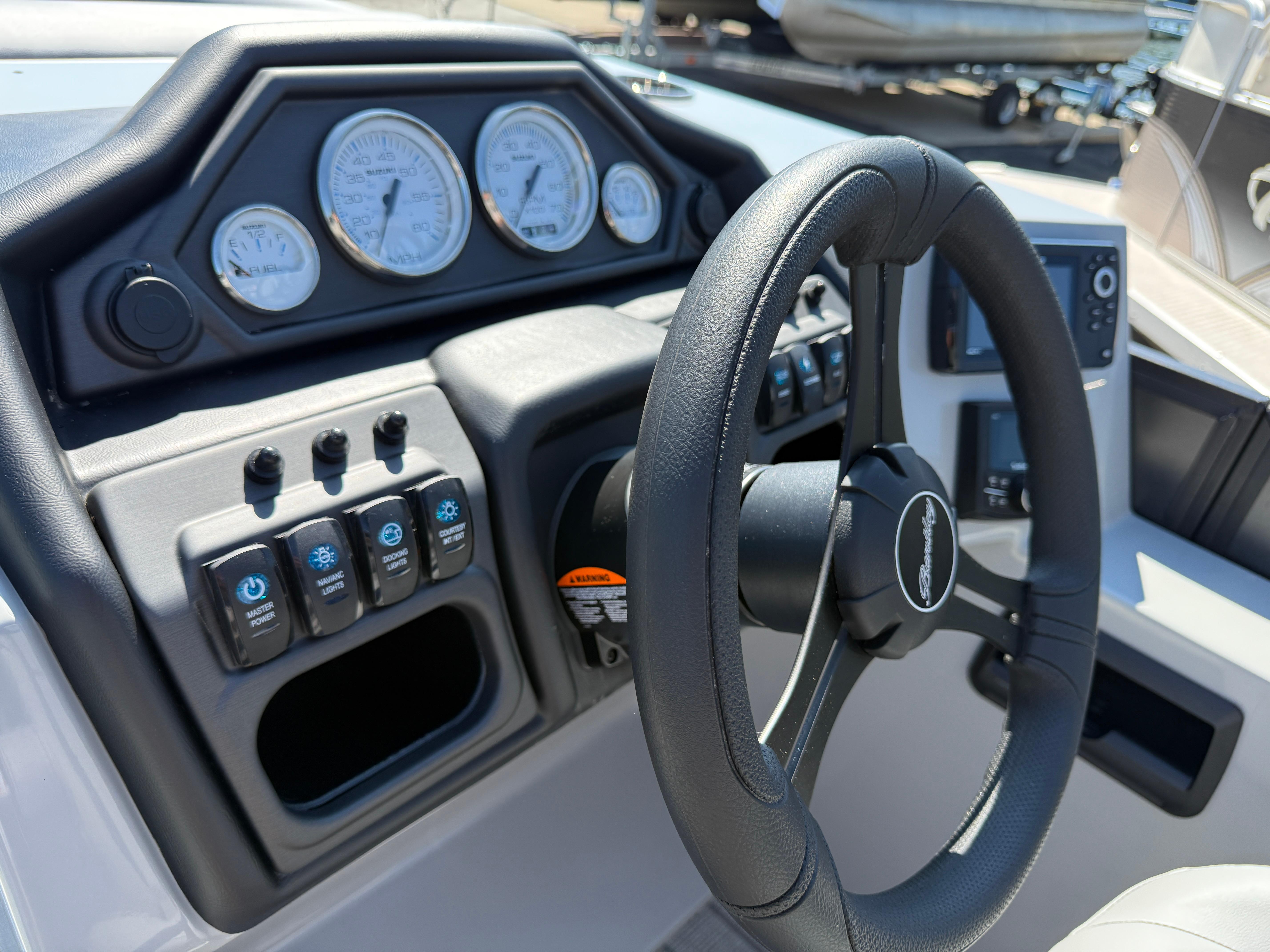 Steering console of 2026 Bentley Pontoons Legacy 223 Navigator with gauges and controls.