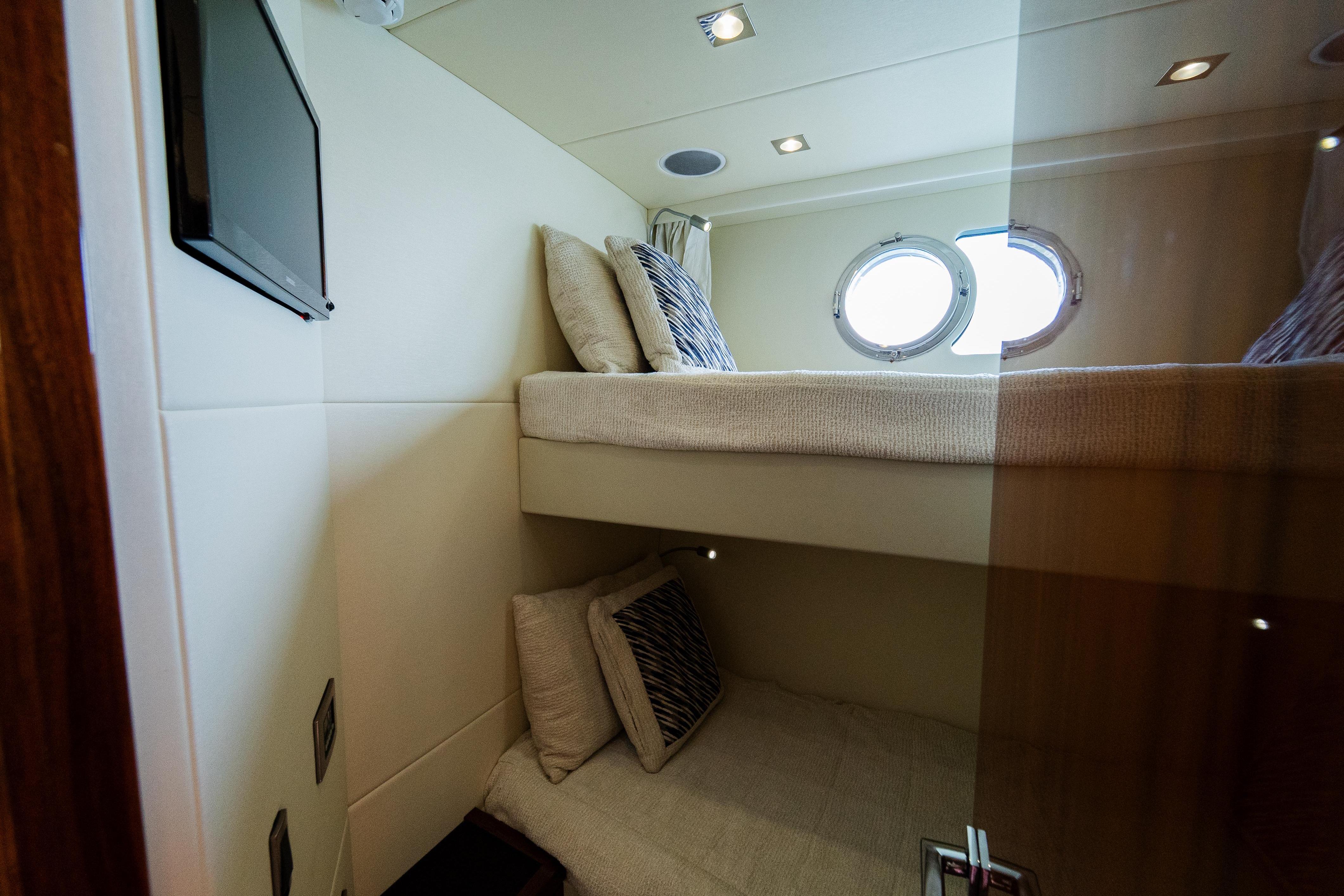 Interior of 2016 Sunseeker Manhattan 65 yacht with cozy bunk beds and porthole window.