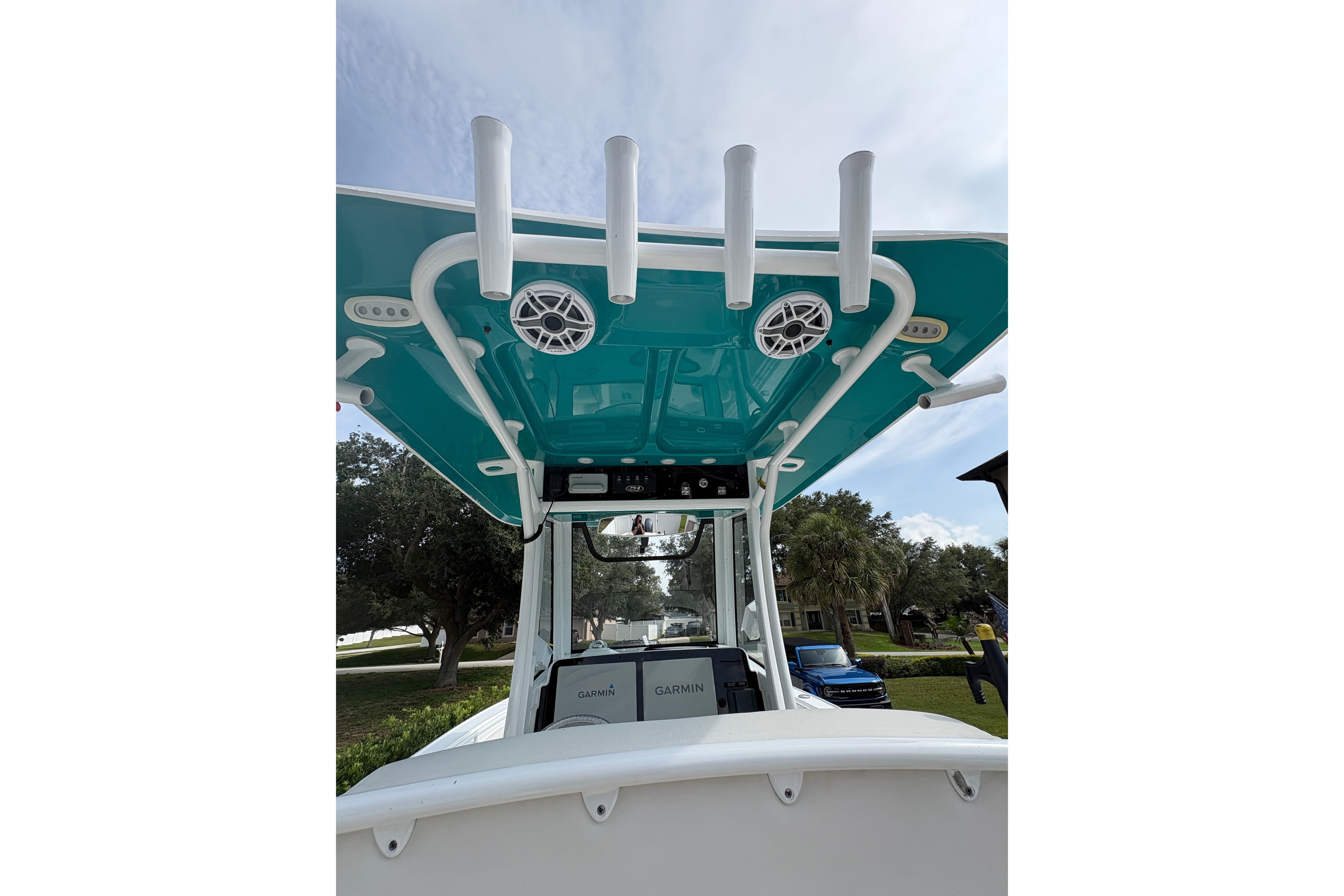 2021 Sea Hunt Ultra 265 SE boat with teal canopy and rod holders.