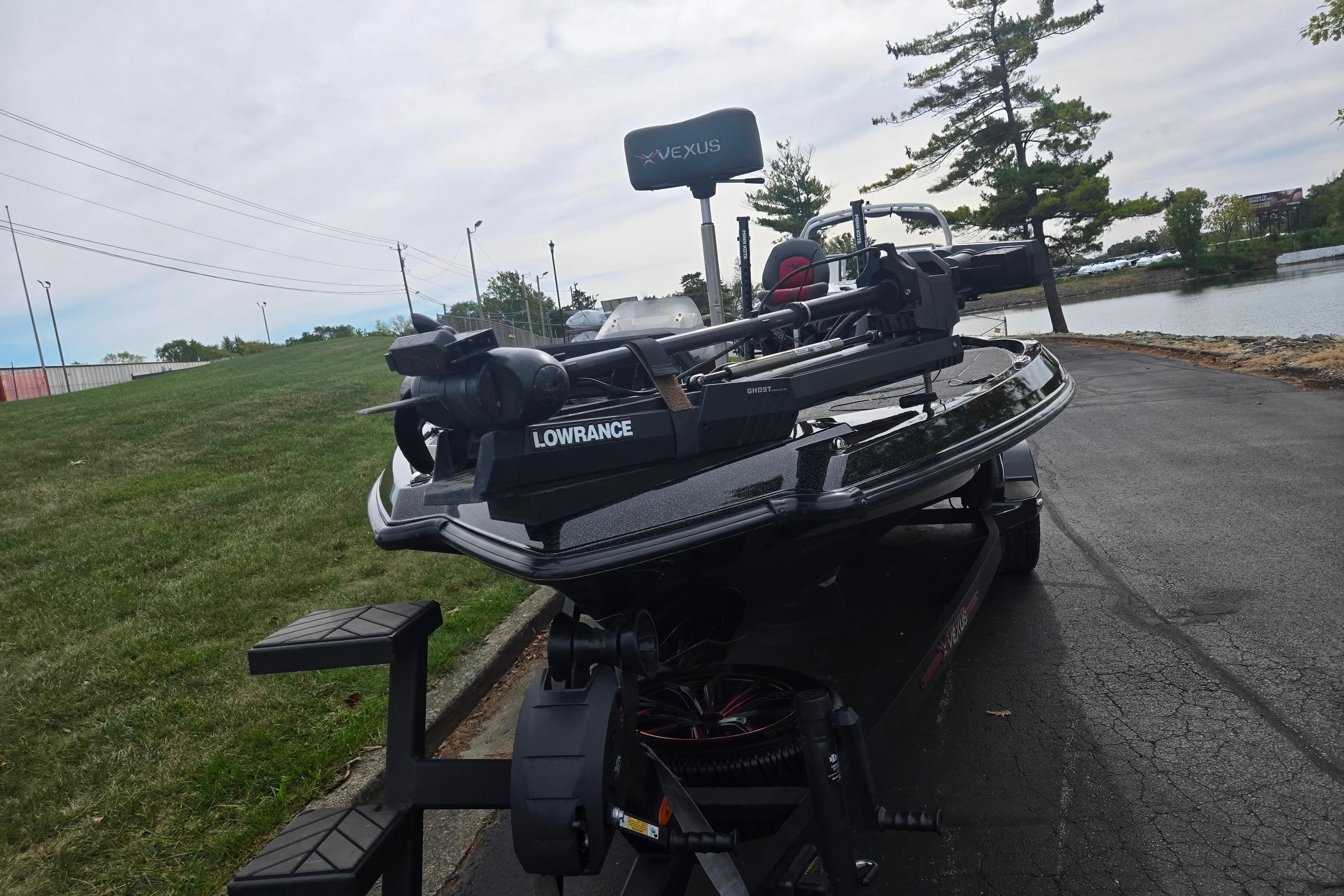 2022 Vexus VX20 boat with Lowrance equipment on a trailer by a lakeside road.