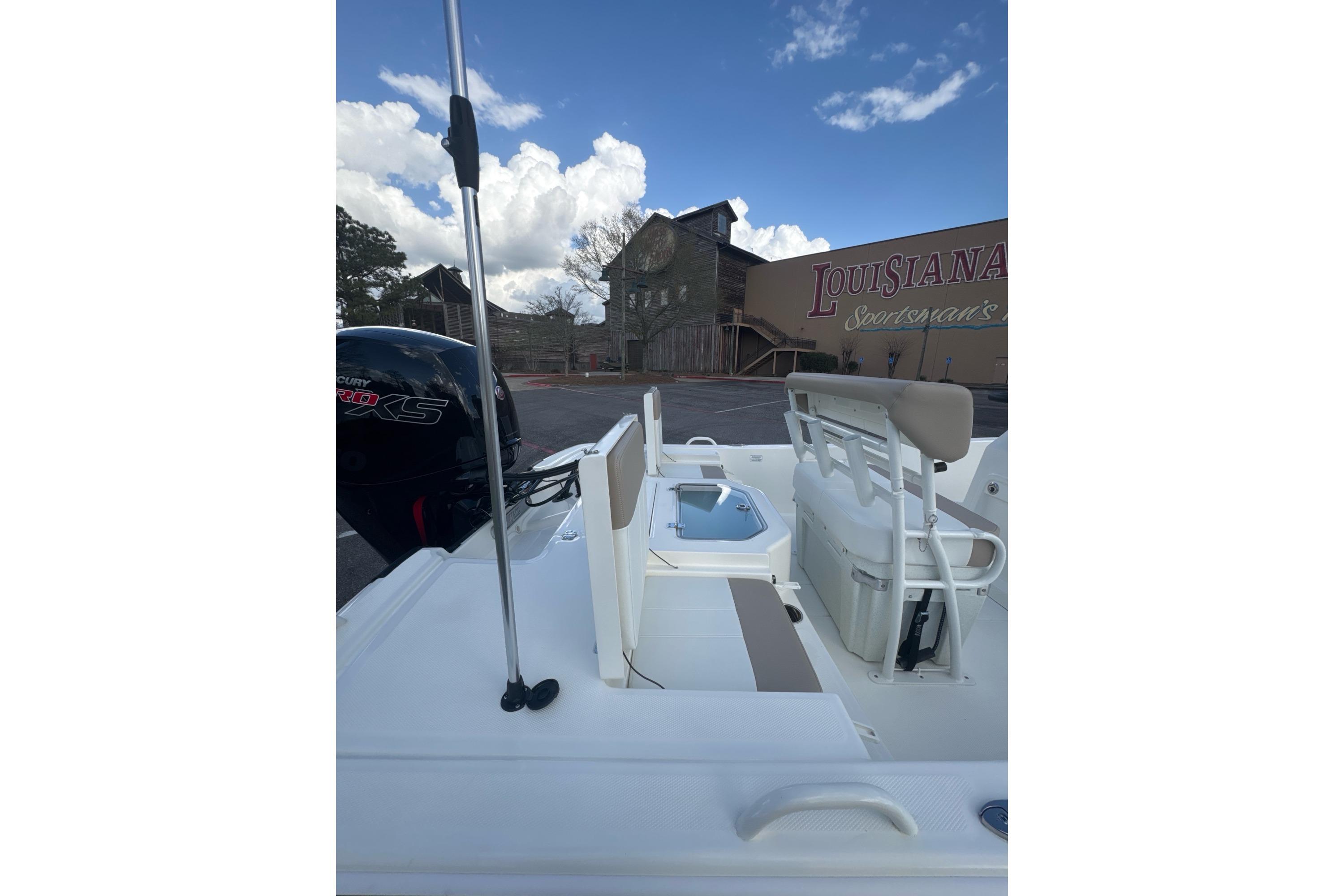 2026 Mako Pro Skiff 19 CC boat with seating and motor, parked near Louisiana Sportsman's building.
