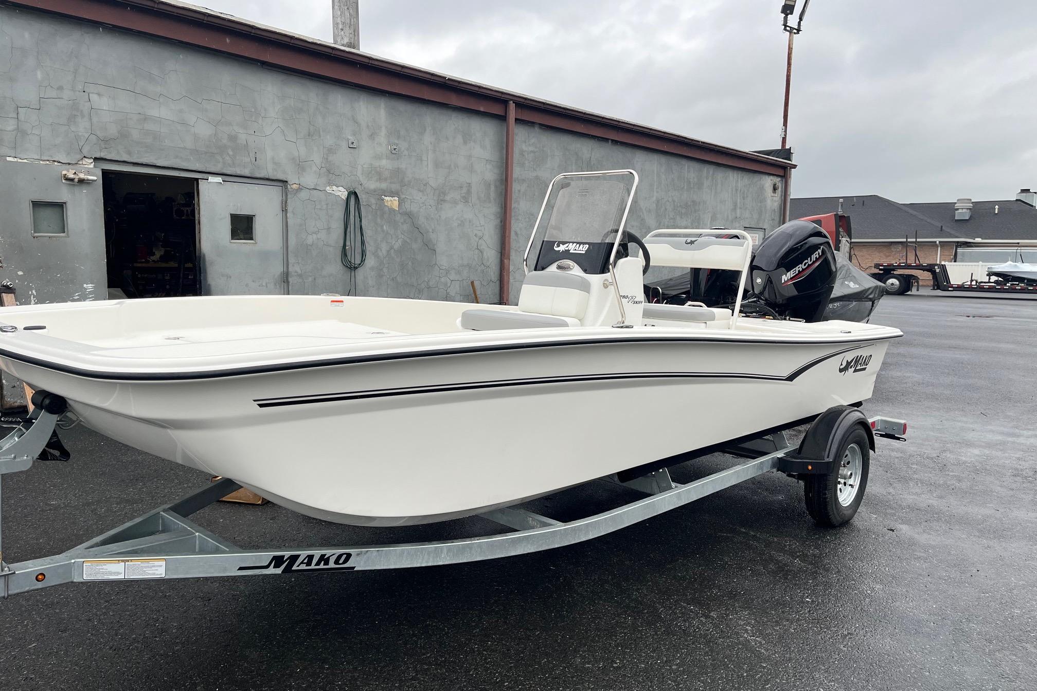 2026 Mako Pro Skiff 17 CC boat on trailer, parked outdoors on a cloudy day.