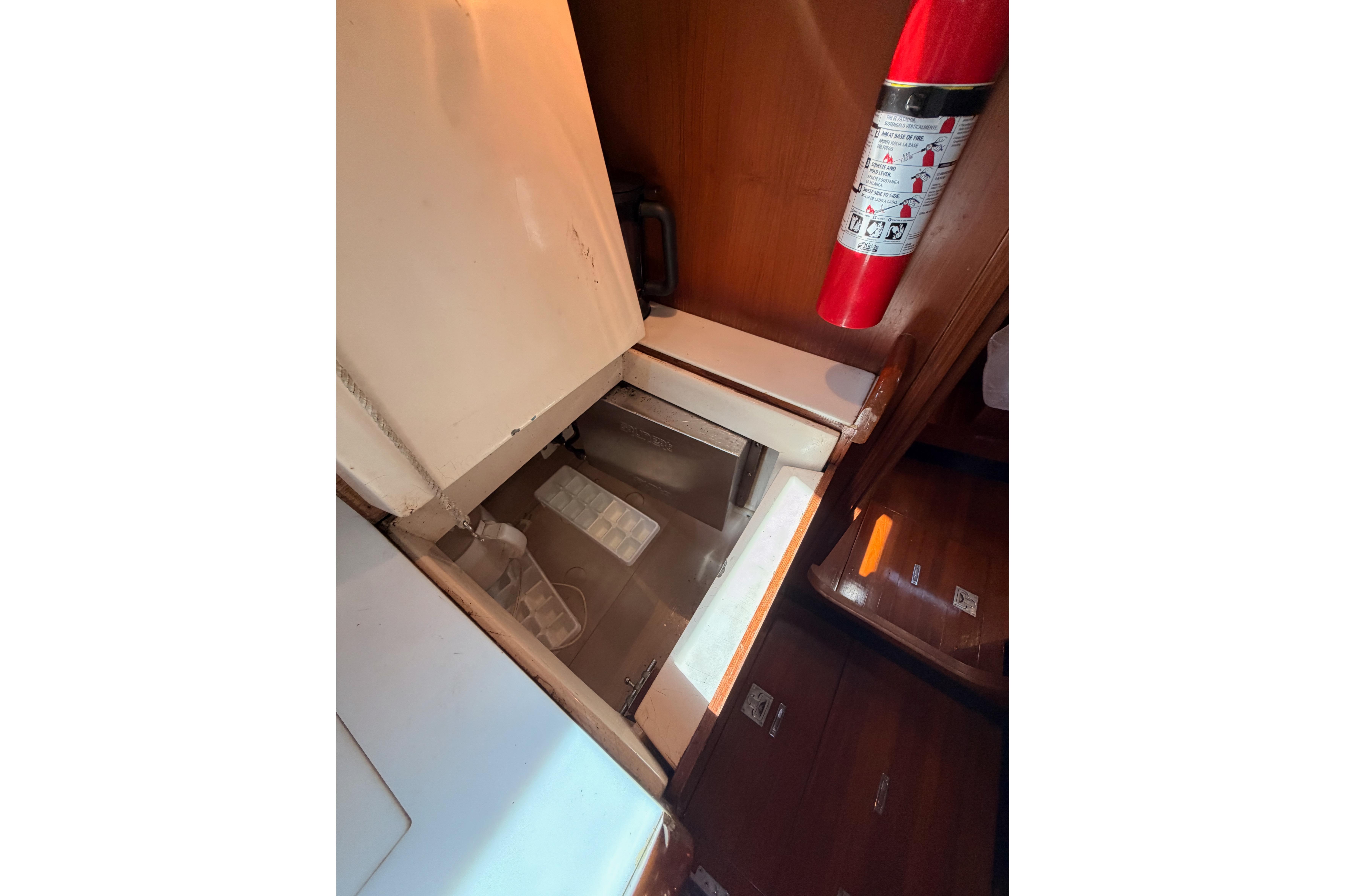 Interior of a 1991 Hylas 51 yacht featuring a built-in storage compartment and fire extinguisher.