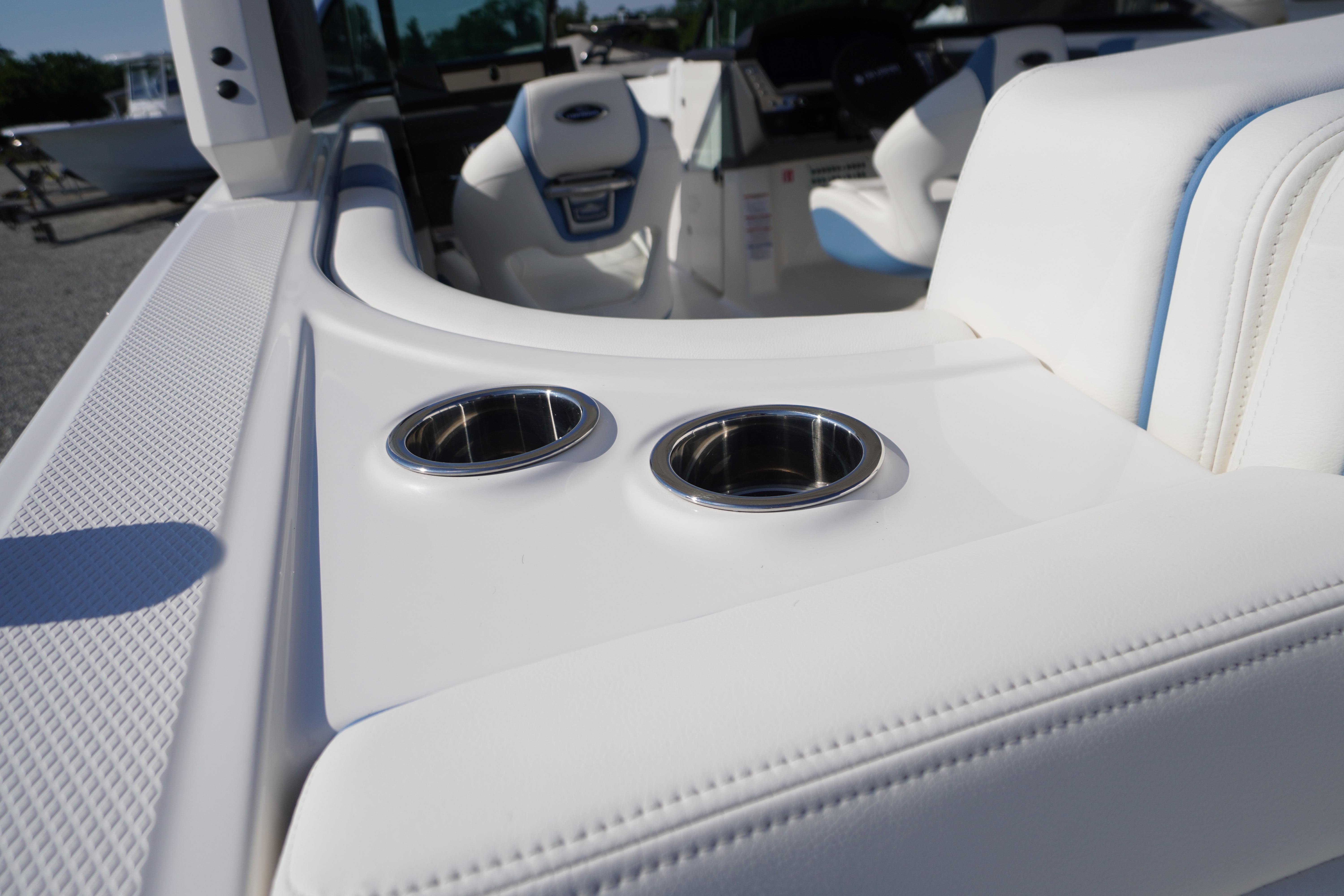 2026 Chaparral 270 OSX boat interior with white seating and stainless steel cup holders.