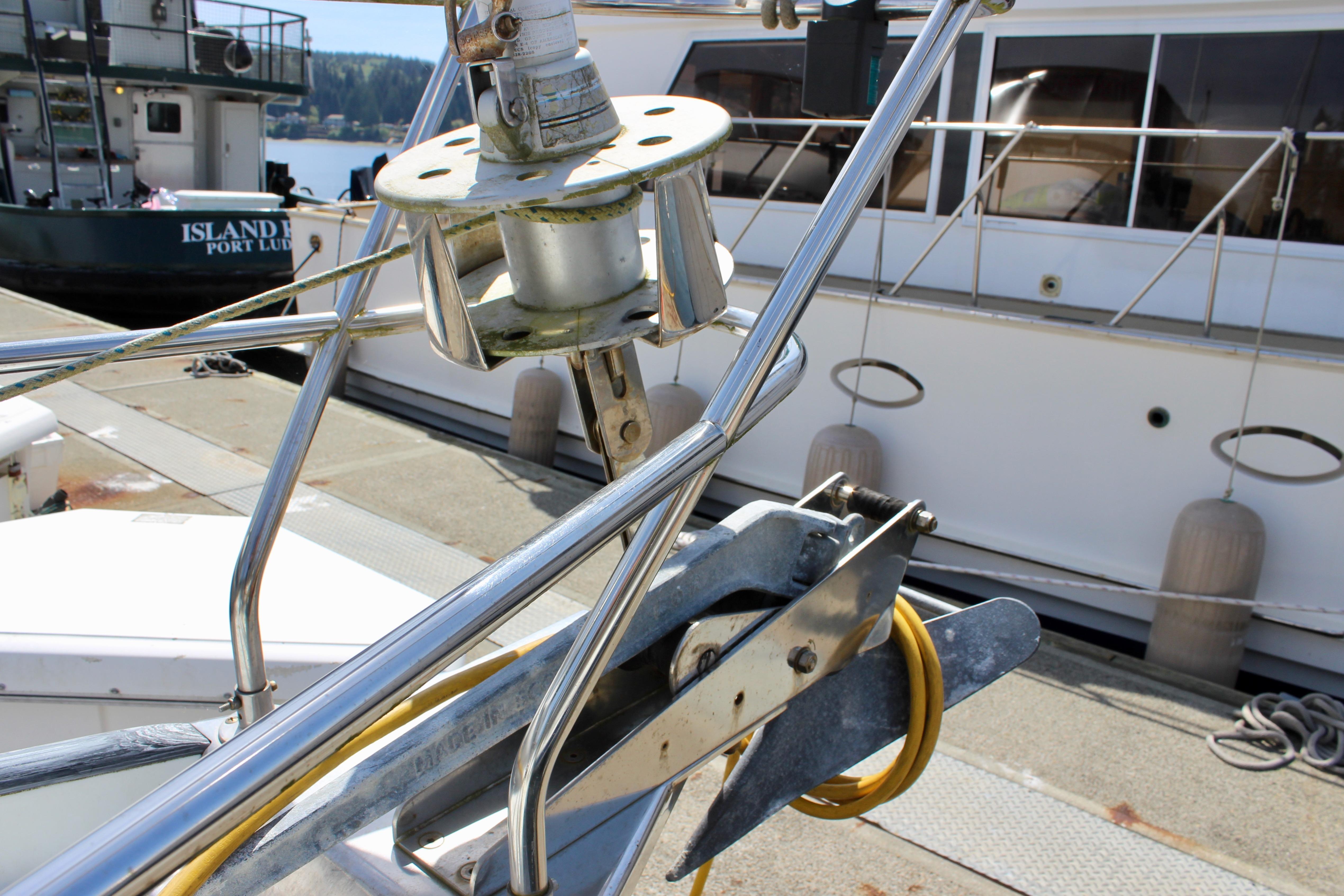 Bow of 1993 Freya 39 sailboat with anchor and docked boats in background.