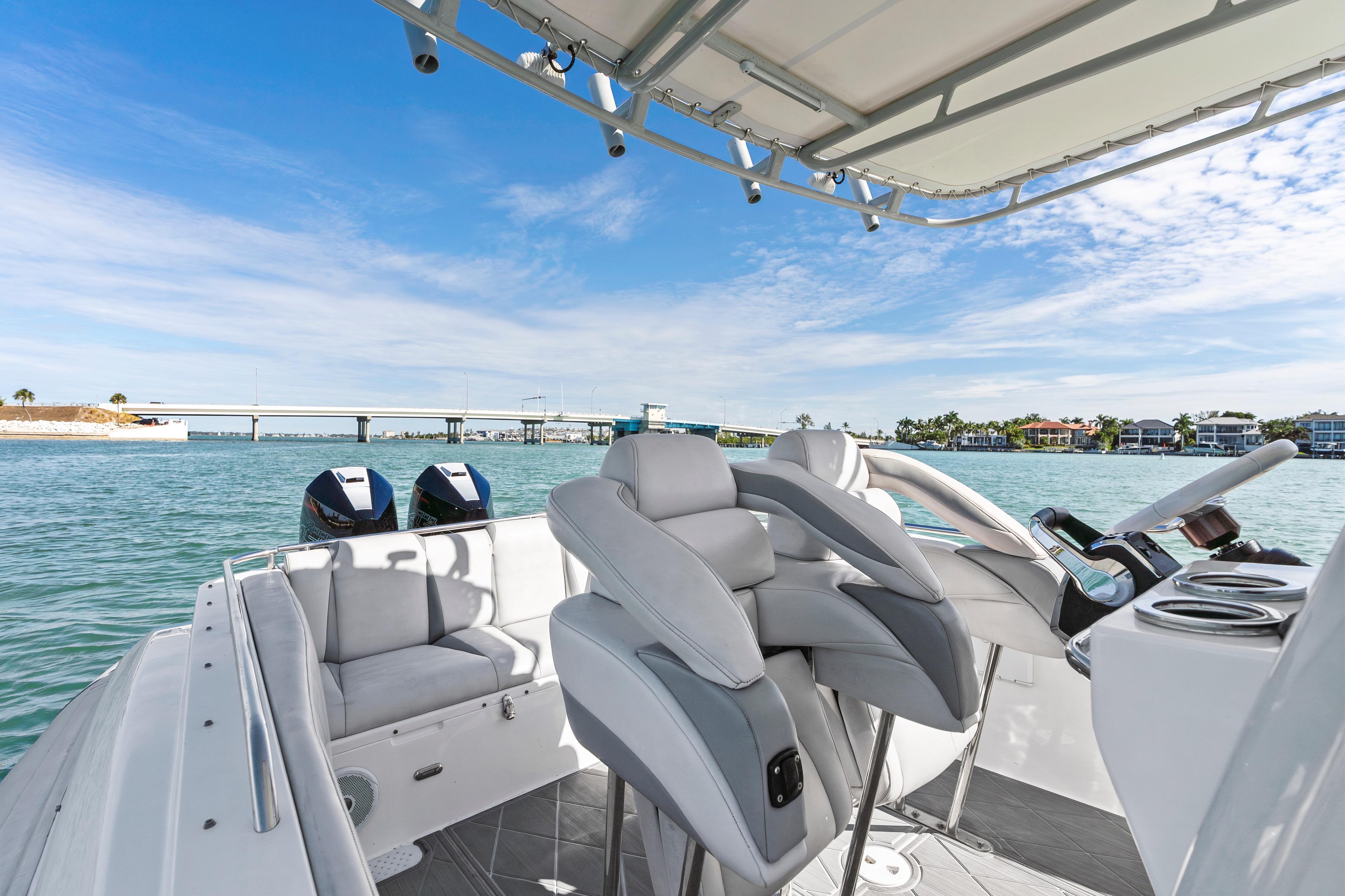 Interior view of 2014 Airship 330 boat with modern seating and scenic waterfront backdrop.