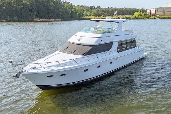 2003 Carver 570 Voyager Pilothouse yacht on a serene lake.