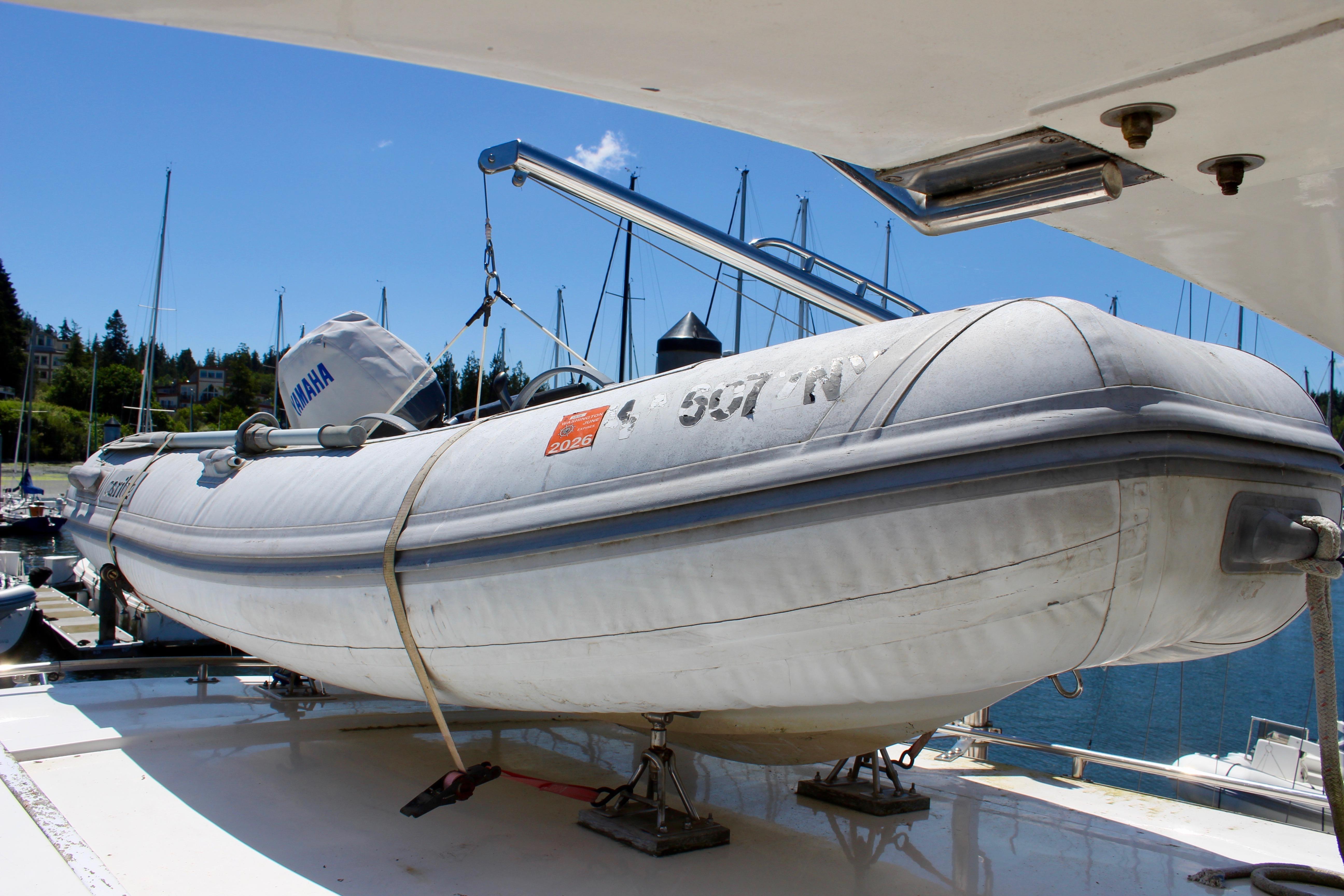 Inflatable boat with Yamaha motor on Kha Shing Spindrift 46, 1986 model, docked at marina.